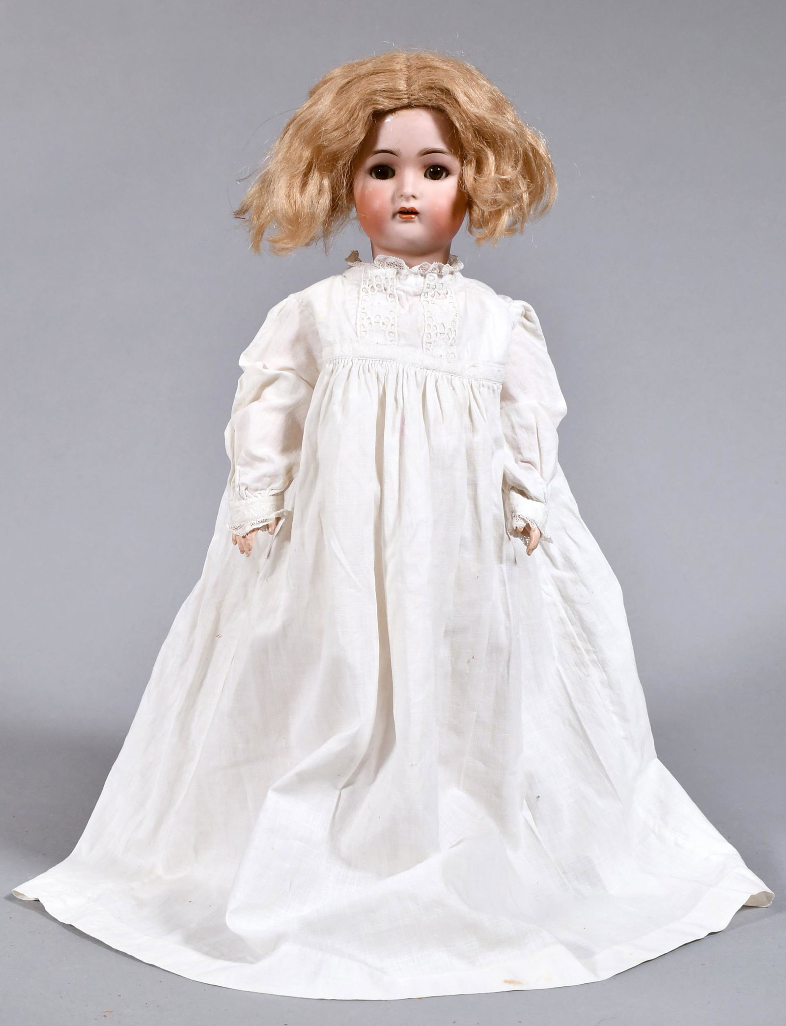 ANTIQUE KAMMER AND REINHARDT BISQUE HEAD DOLL.: With a Simon and Halbig head, sleep eyes, and vintage white night gown. Doll has slightly open mouth with exposed top teeth. 17”H.