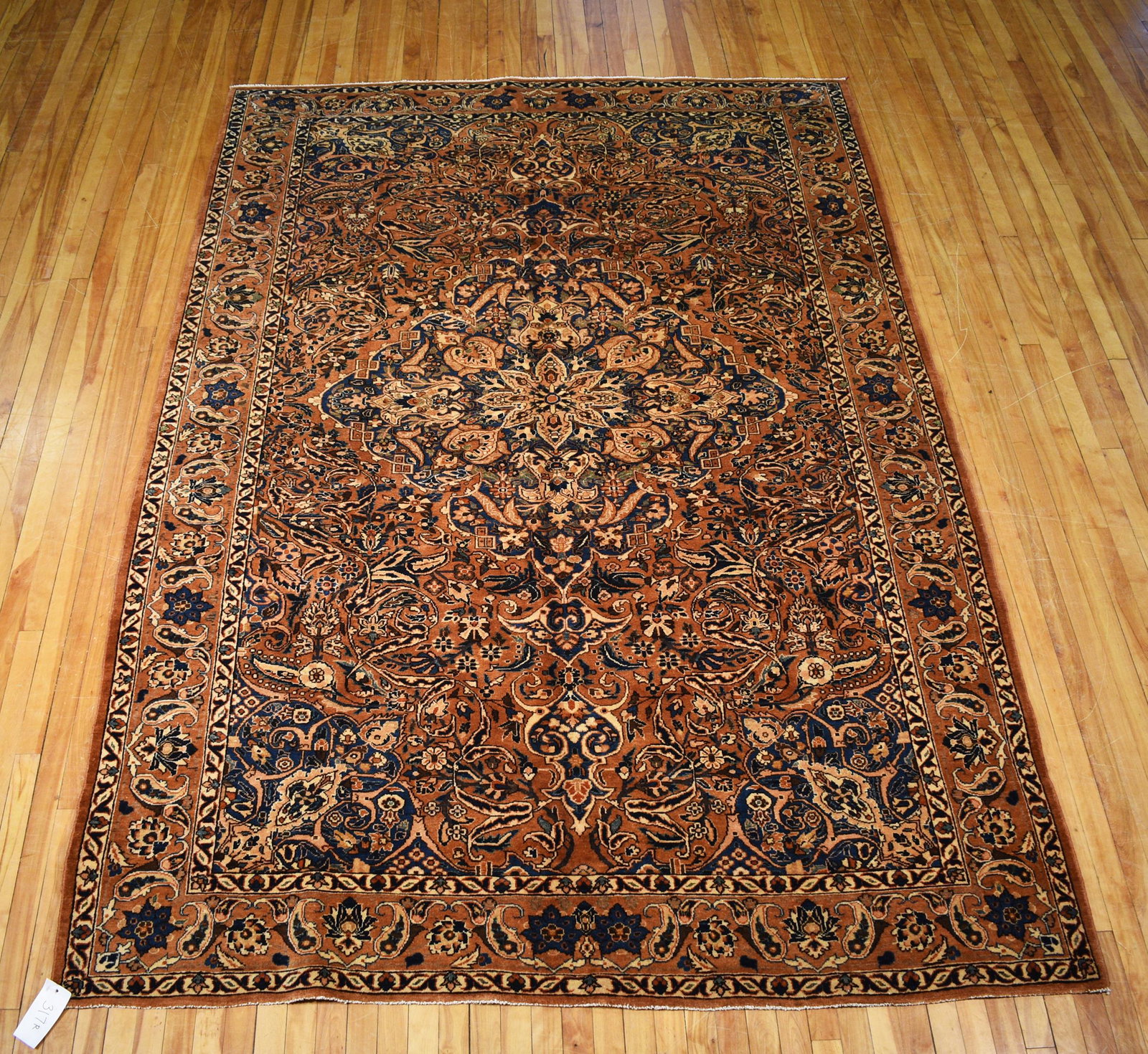 ANTIQUE PERSIAN RUG, 6’9” X 9’10”: Antique Persian area rug, with blue, blue-green and ivory designs on rich caramel ground, 6’9” x 9’10”.