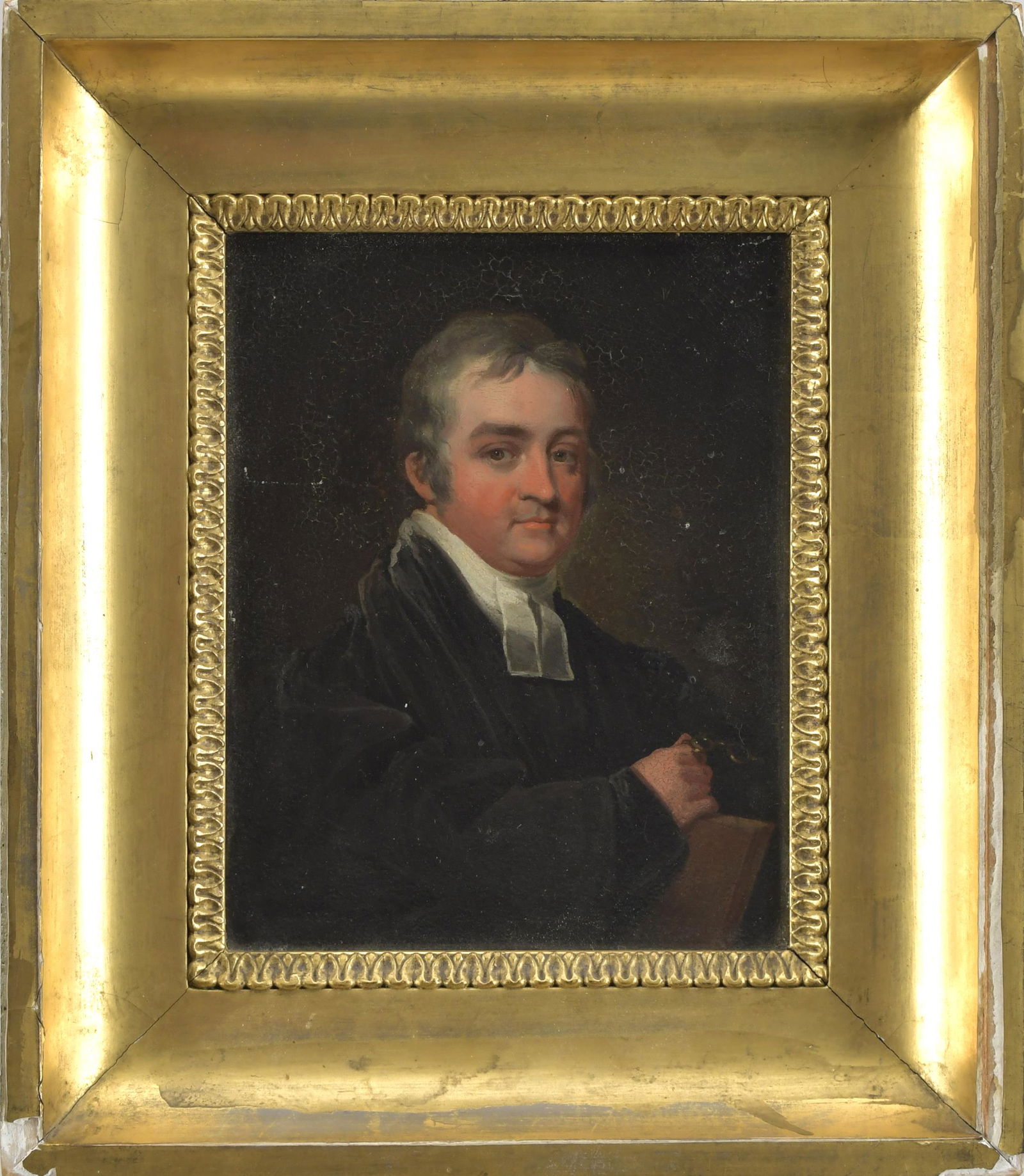 ATTRIB GILBERT STUART OIL, PORTRAIT OF REV. GARDINER.: Oil on wood board, portrait of man holding book and spectacles, identified as Rev. Sylvester John Gardiner on reverse, attributed to Gilbert Stuart, with label on reverse from the collection of Seth M