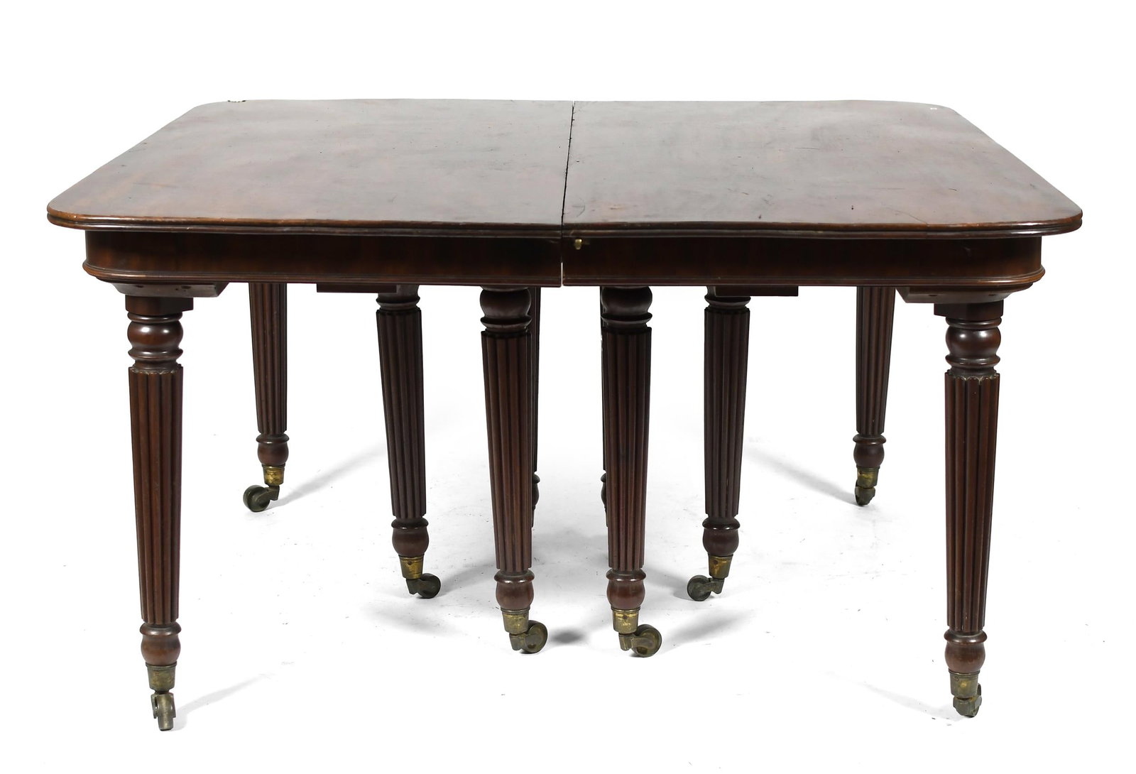 EARLY 19TH C. MAHOGANY BANQUET TABLE.: Ca. 1810-20, a unique form of this period, with a rich mahogany reeded edge top, beaded apron on bold reeded legs, and cup caster feet, 29.5”H x 54”closed x 52” x 131”L fully e