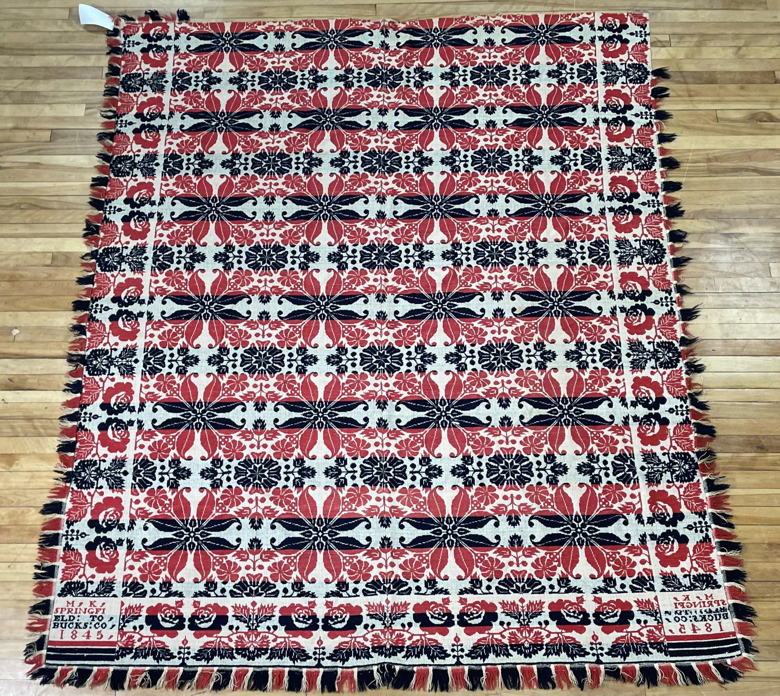 1845 RED AND BLUE HOMESPUN, BUCKS CO.: An 1845 red, white and blue homespun coverlet inscribed 'M.K. Springfield Bucks Co 1845', 74” x 94”.