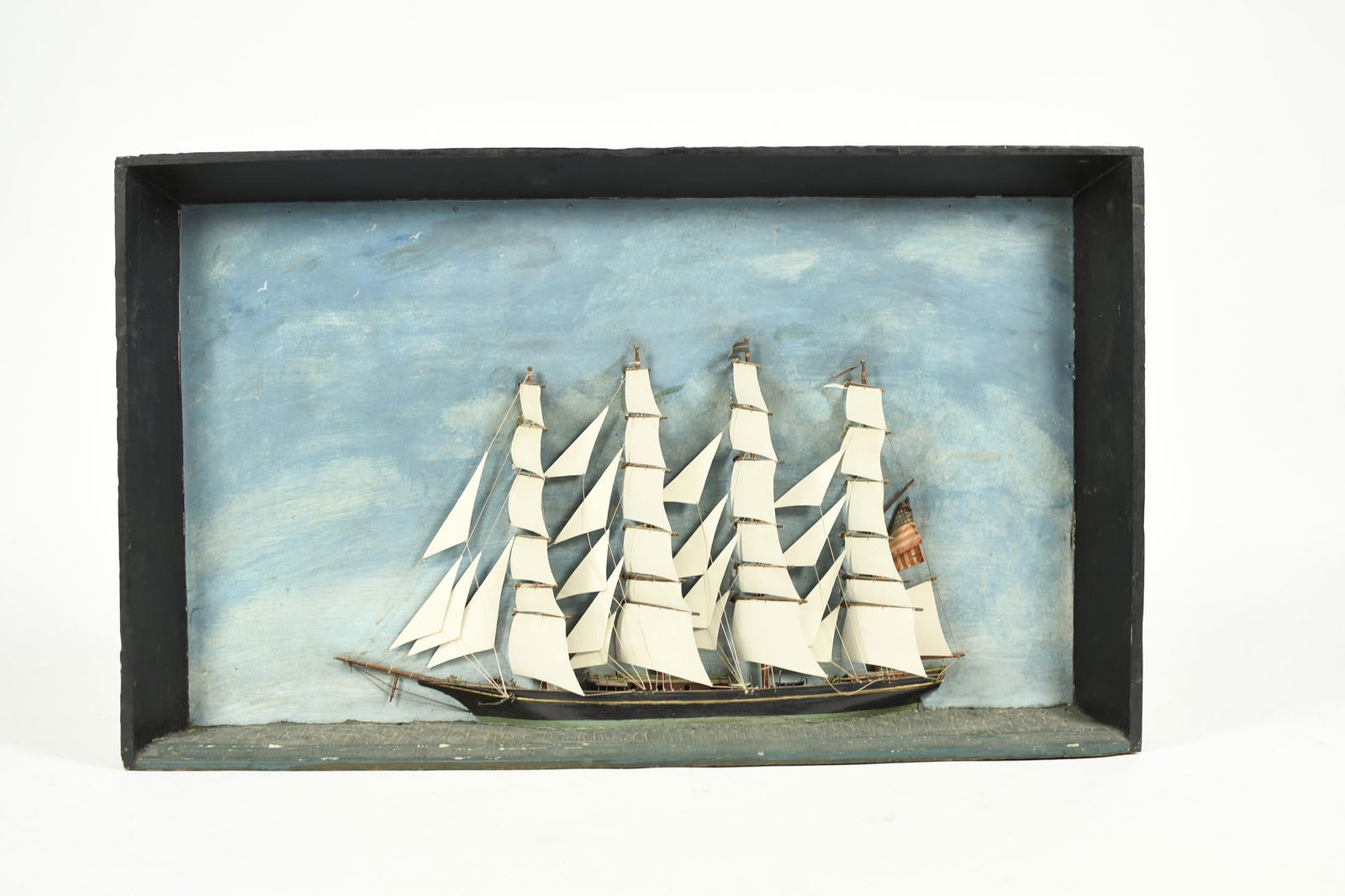 19TH C. SHIP DIORAMA.: An antique large scale ship diorama with a well executed folky depiction of a four-masted clipper ship at sea, 25”H x 34”W x 9”D.