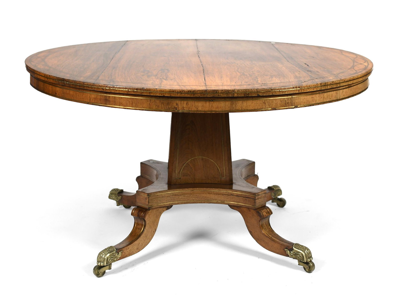 19TH C. ROSEWOOD REGENCY INLAID BREAKFAST TABLE.: Ca. 1820-30 breakfast table with a brass inlaid circular tilt-top supported by a squared tapered pedestal with four down swept legs, on swiveling brass castors, 29”H x 52” dia. .