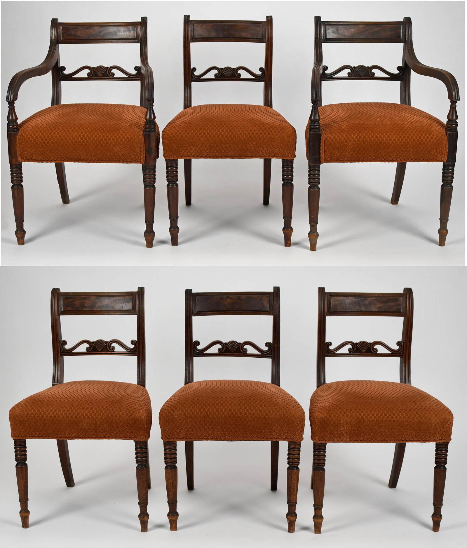 SET OF SIX 19TH C. REGENCY DINING CHAIRS.: Ca. 1820's English Regency mahogany dining chairs, two arm and four sides, all with shell and scroll carved back splats, with rust colored fabric seats, on turned legs. Arm 32”H x 21”W x 2