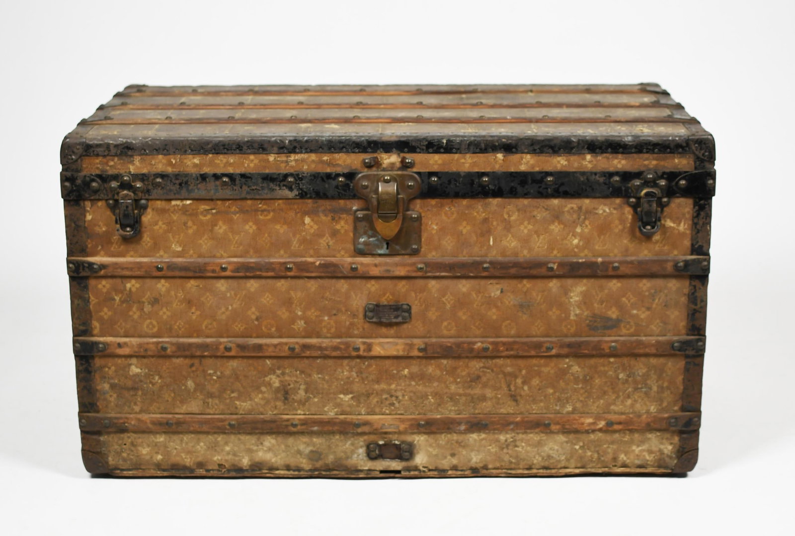 ANTIQUE LOUIS VUITTON STEAMER TRUNK.: Serial # 137781, ‘LV’ monogrammed exterior with stamped hardware, labeled on interior 'Louis Vuitton Paris London', 23”H x 39.5”W x 21.5”D.