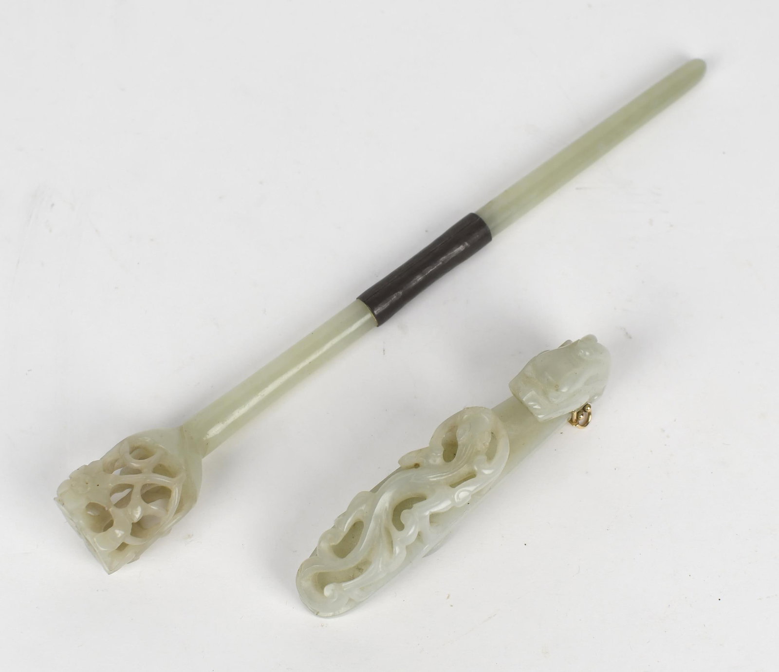 TWO ANTIQUE CARVED JADE ITEMS.: An 18th C. Chinese jade belt buckle with dragon carving, with an added contemporary 14k gold bracket, 4.25”L. A 19th C. Japanese carved jade hairpin, with carved decoration at end and a silver w