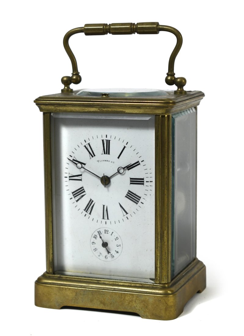 TIFFANY & CO. SONNERIE CARRIAGE CLOCK.: Tiffany & Co. Sonniere brass carriage clock, enamel dial marked TIffany & Co. with beveled glass sides and back, works marked France. 5.5”H handle down. 3.5”W x 3”L. With original pu