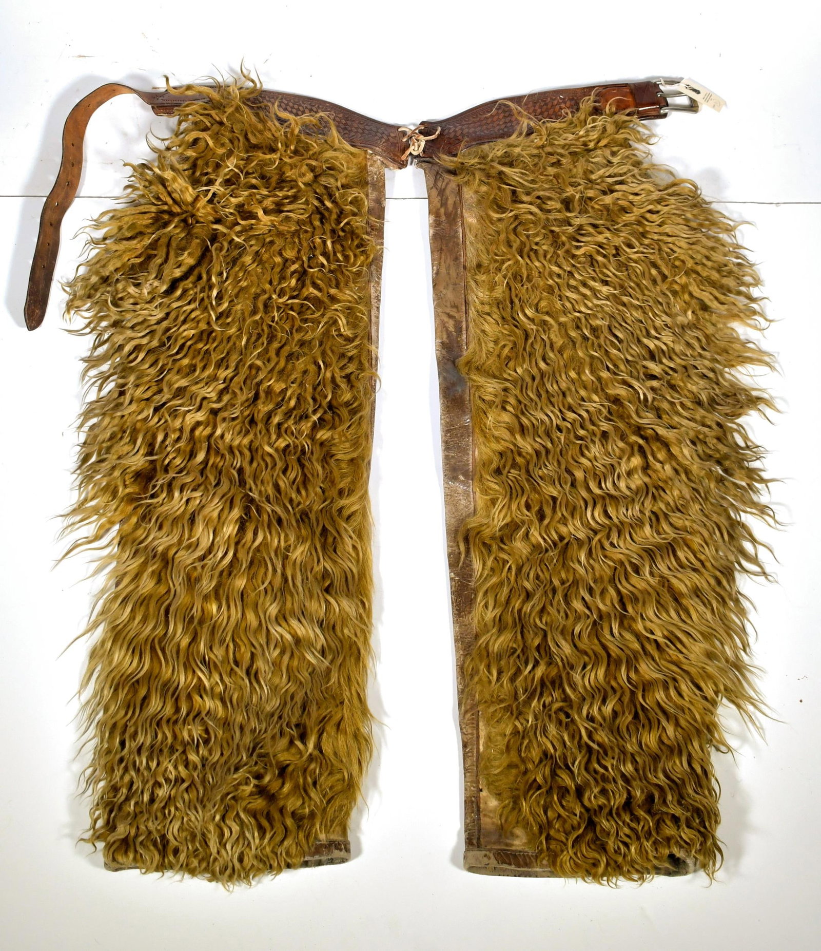 VINTAGE E.C. LEE PIERRE SOUTH DAKOTA COWBOY CHAPS.: Early 20th C. Leather and angora wooly chaps with stamp of E.C. Lee Pierre South Dakota, 37”L, width each leg 11”.