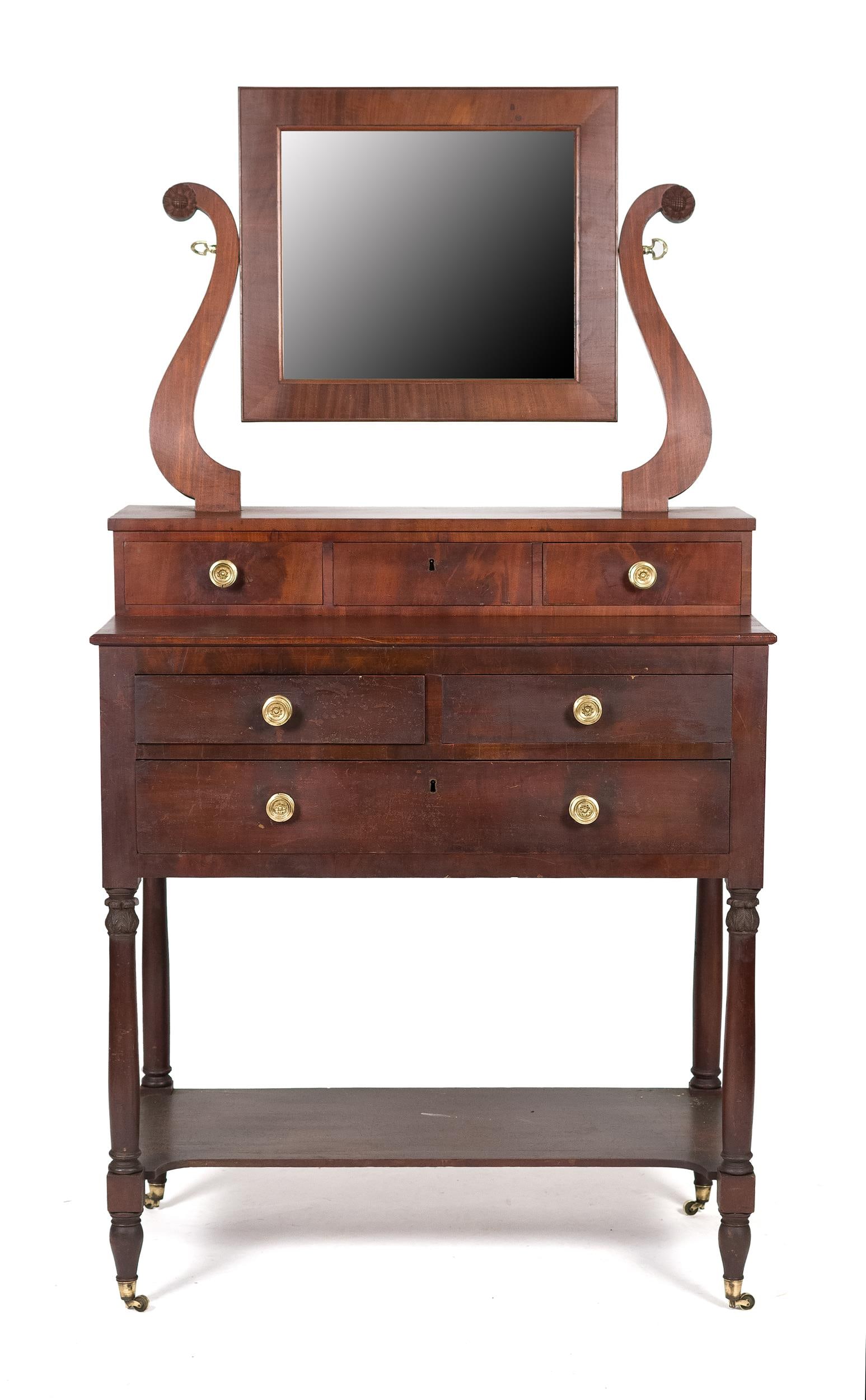 FEDERAL NEW YORK CARVED MAHOGANY DRESSING TABLE.: Ca. 1820, New York school, or Duncan Phyfe, deck top dressing table with floral carved harps and three drawers in deck top, over a a case with two short over one long drawer and acanthus carved posts,