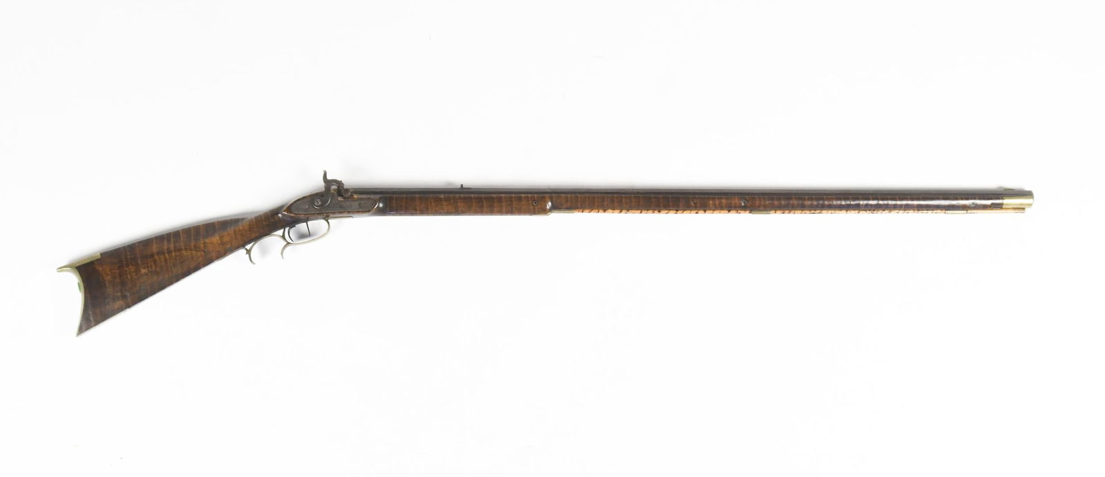 19TH C. TIGER MAPLE KENTUCKY LONG GUN.: From the first half of the 19th C. a tiger maple, full stock Kentucky long rifle, with percussion cap mechanism, engraved lock plates, brass butt and trigger guards. 56.75”L x barrel 40.5”