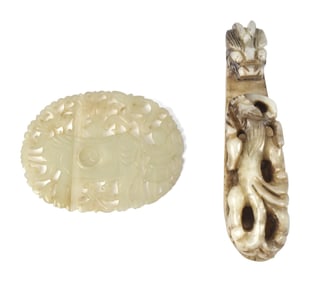 TWO CARVED CHINESE JADE BELT BUCKLES.