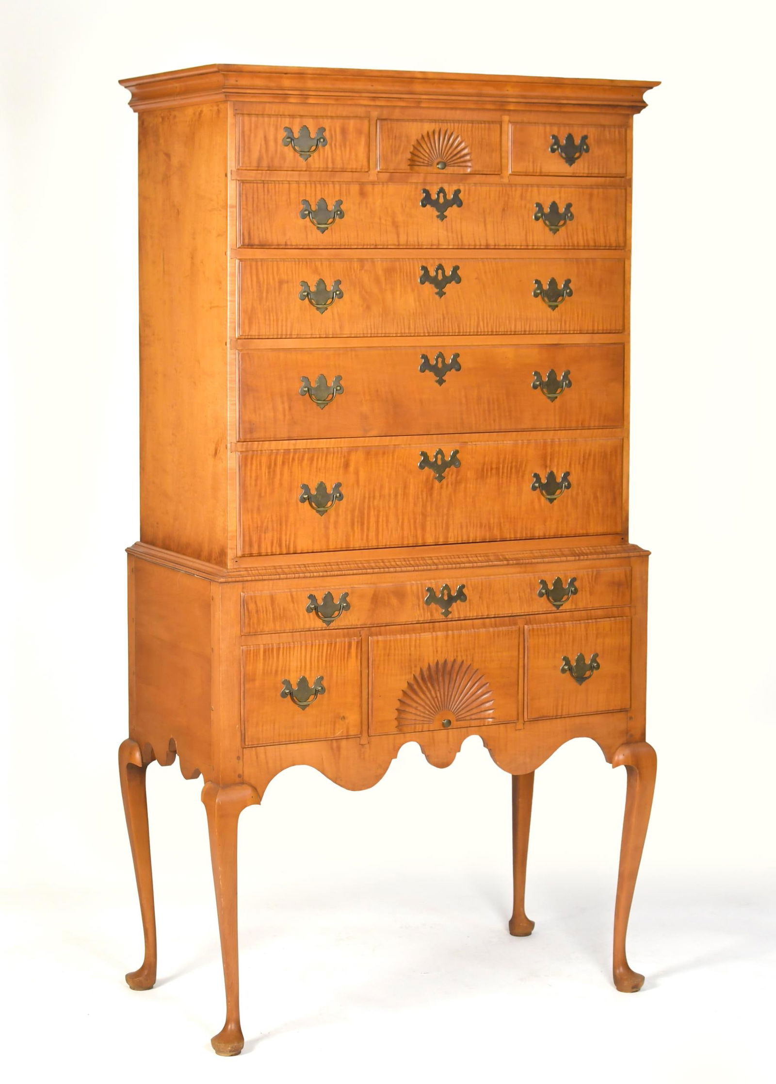ELDRED WHEELER QUEEN ANNE STYLE TIGER MAPLE HIGHBOY.: A 20th C. two part Queen Anne style tiger maple highboy, labeled Eldred Wheeler. Top section with an applied molded cornice, and three short of four long drawers. Lower section with one long over thre