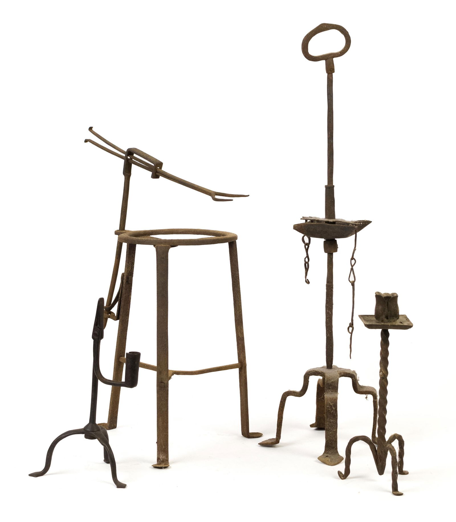 EARLY IRON LIGHTING AND RELATED, 4 PCS.: Early iron adjustable grease lamp, 24”H. An iron tripod rush light, 10”H. Iron hand forged twisted handle light, 10.5”H. Penny foot iron trivet with adjustable fork, 13” to 18&