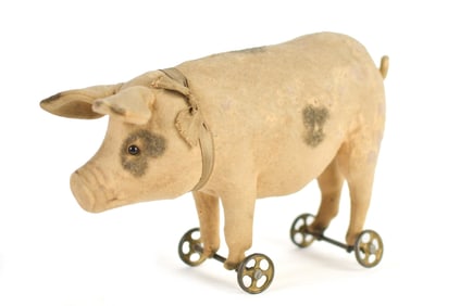 ANTIQUE STEIFF FELT PIG ON METAL WHEELS.