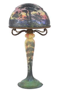 FINE DAUM NANCY SUNSET CAMEO GLASS LAMP.: A fine ca. 1910 Daum Nancy Sunset cameo glass table lamp, internally decorated with sunset landscape overlooking lake, on a tree form base. Shade signed Daum Nancy with Crois de Lorraine, four cast br