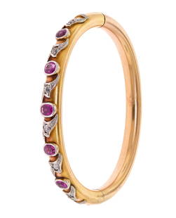 ANTIQUE 10K GOLD PINK SAPPHIRE & DIAMOND BANGLE.: A 10k yellow gold (stamped) hinged bangle with platinum settings, set with approx. 1.65 ct. tw. faceted cushion cut, medium dark, strongly purplish pink sapphires with approx. .65 ct. tw. Old Mine and