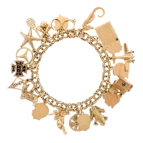 VINTAGE 14K GOLD CHARM BRACELET W/ MANY CHARMS.