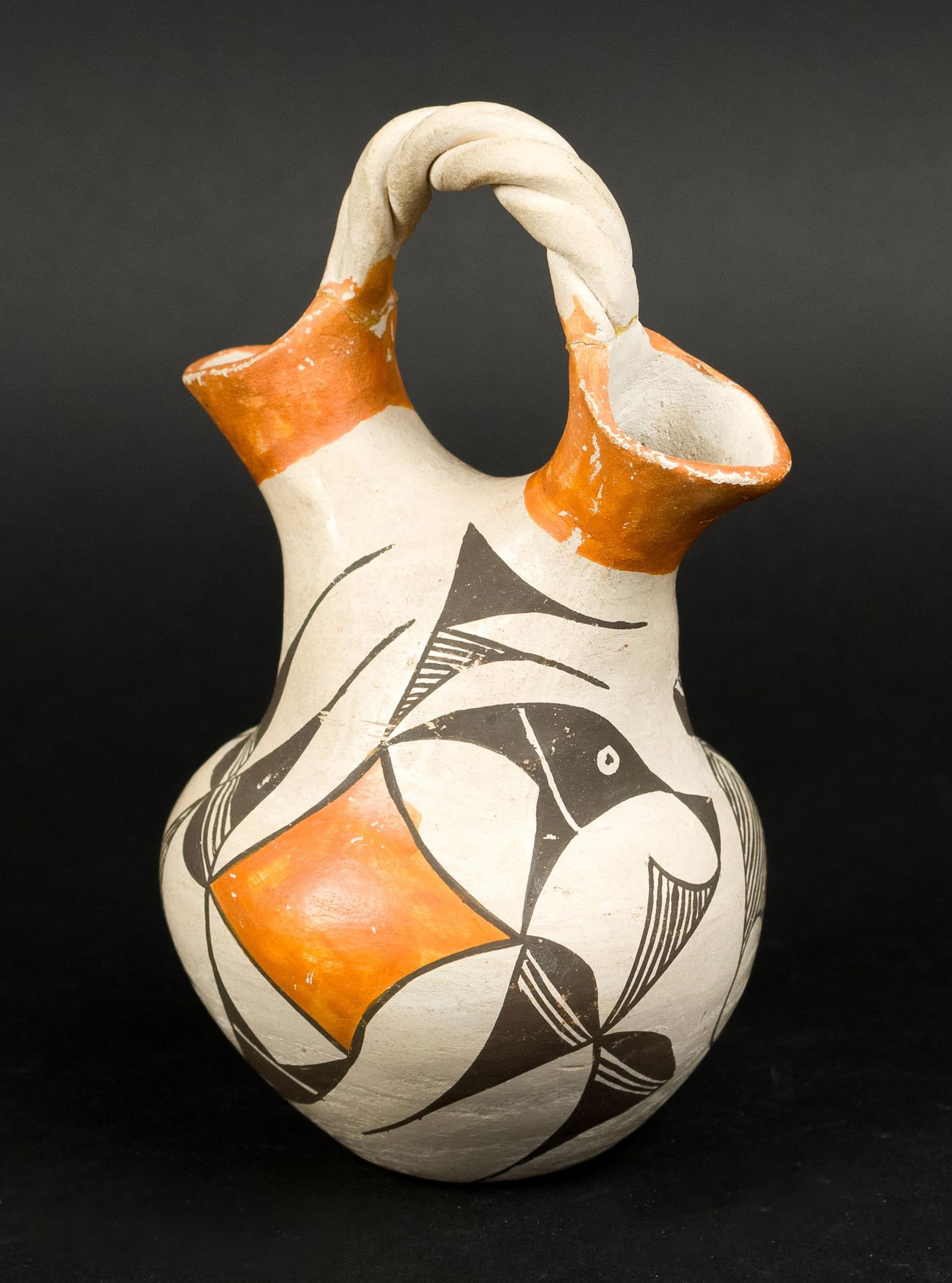 ACOMA WEDDING VASE, CARL MOON PROV.: An antique Acoma pottery wedding vase with two spouts and woven handle, in black, white, and orange glaze, signed on bottom Acoma N.M. From the estate of Carl Moon.7”H x 4”dia.