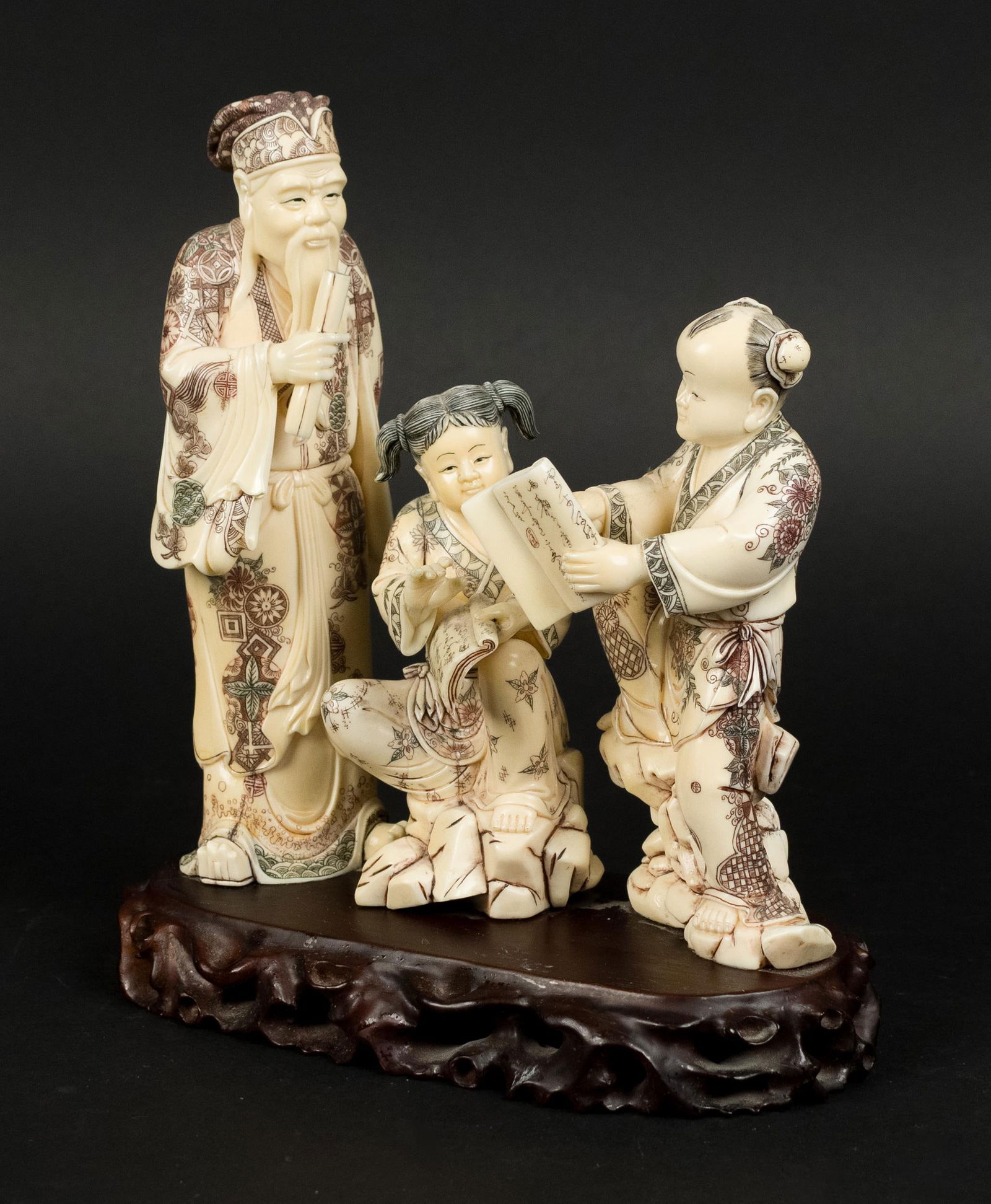 VINTAGE CHINESE CARVED BONE FIGURAL GROUP.: A vintage Chinese carved bone figural group, with elder teaching two children. 9.5”H x 9”W.