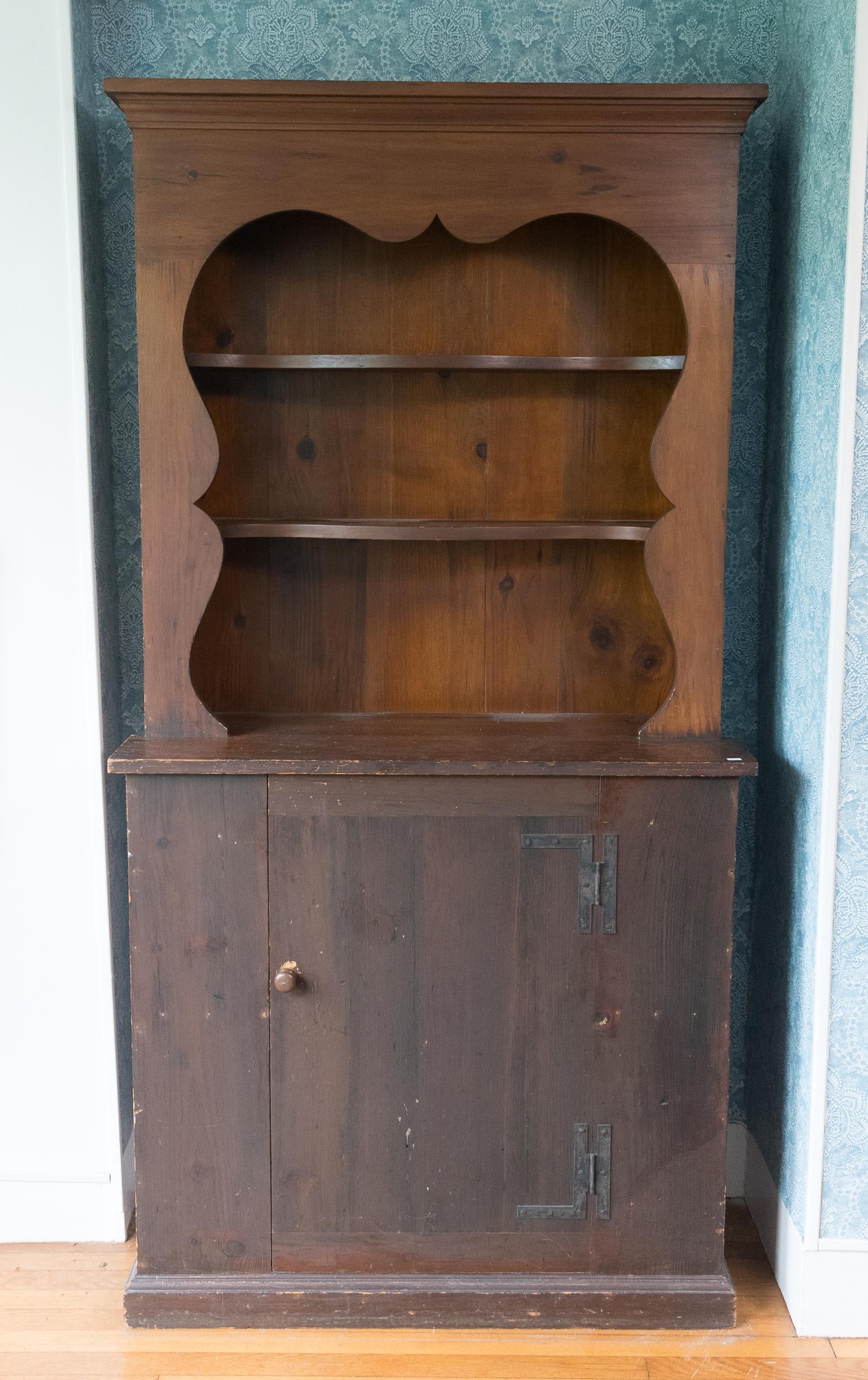 WALLACE NUTTING PINE SET BACK CUPBOARD.: Early 20th C. small pine open-top set-back cupboard with scalloped edge and two fixed shelves, over a single door with H&L iron hinges, branded on the backboards Wallace Nutting with paper label, 73.5