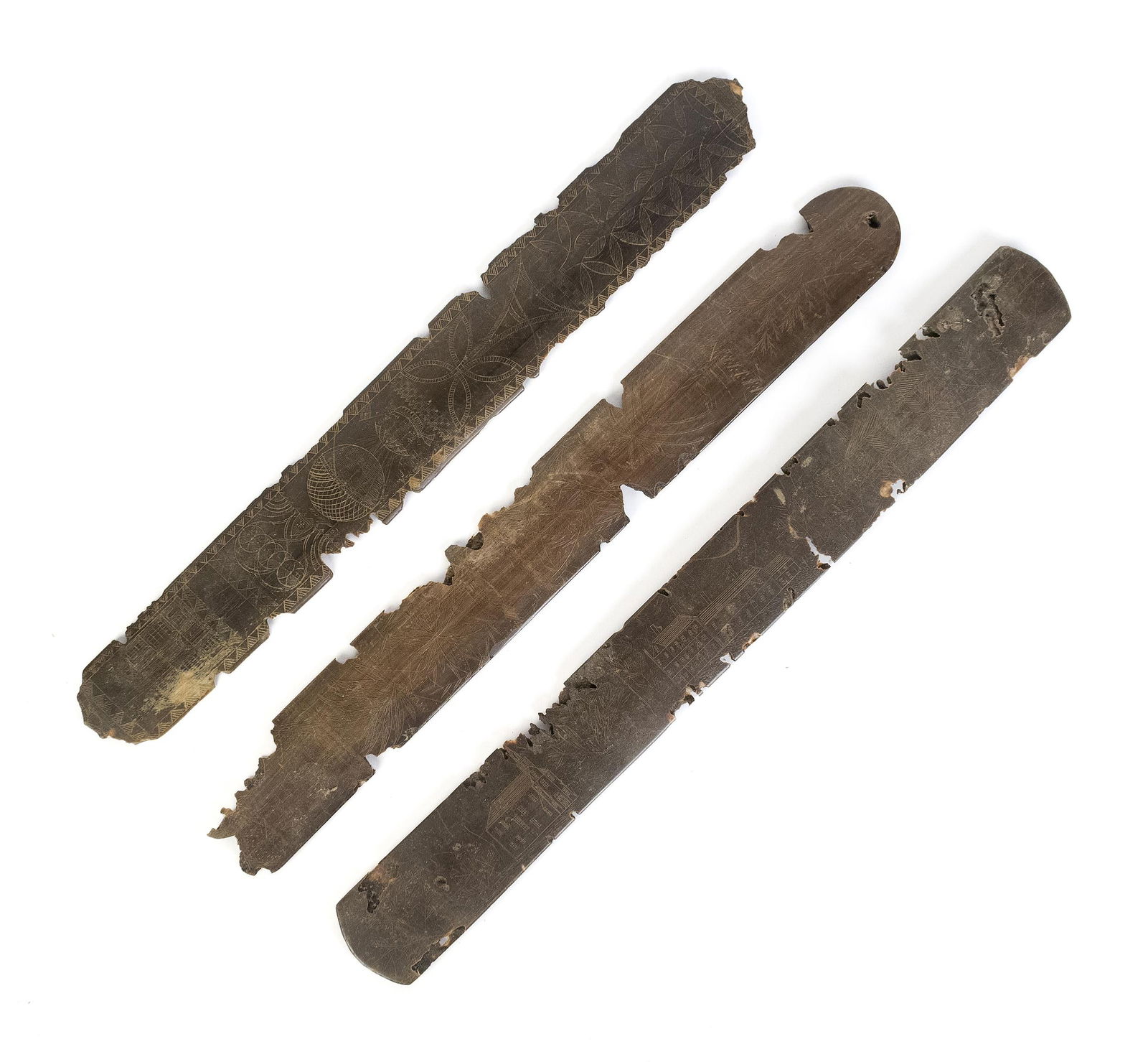 THREE EARLY PAN BONE CARVED BUSKS.: Three 19th C. scrimshawed pan bone corset busks, one depicting houses, church, and more, another has balloons and pin wheels, the last one has ship, palm trees, and vines, the reverse signed and dated