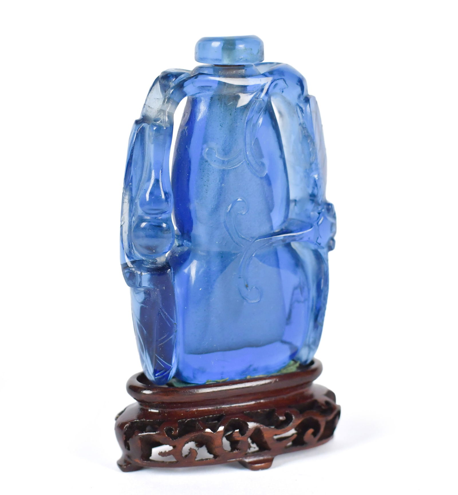 ANTIQUE CHINESE PEKING GLASS SNUFF BOTTLE.: A Qing period Chinese carved Peking glass snuff bottle, the body with low-relief scrollwork and stylized ribbon designs, flanked by high arching handles, and topped with a matching glass stopper. Pres
