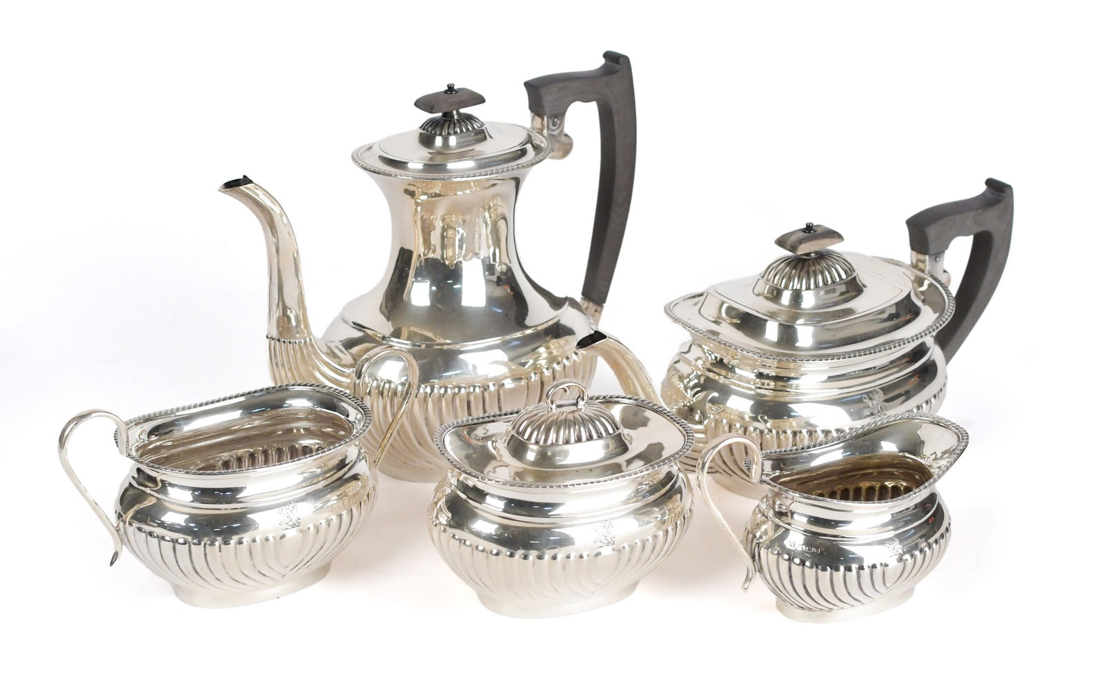 WILLIAM ADAMS STERLING FIVE PIECE TEA SET.: A William Adams, England, sterling silver five piece tea set, with lion holding ring engraving, and ebony handles. Including coffee pot 8.5”H, tea pot 6”H, lidded sugar 4.5”H, waste