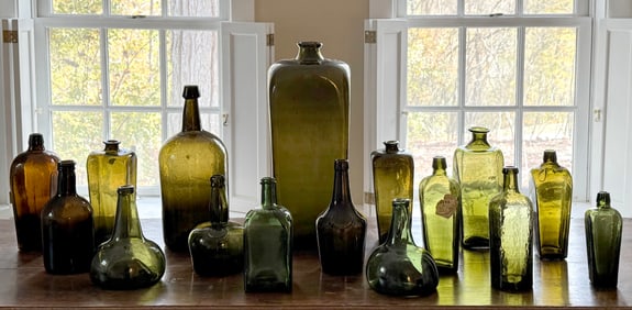 SIXTEEN ANTIQUE COLORED GLASS BOTTLES.