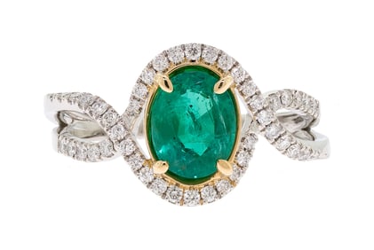 PLATINUM & 18K GOLD EMERALD & DIAMOND HALO RING.