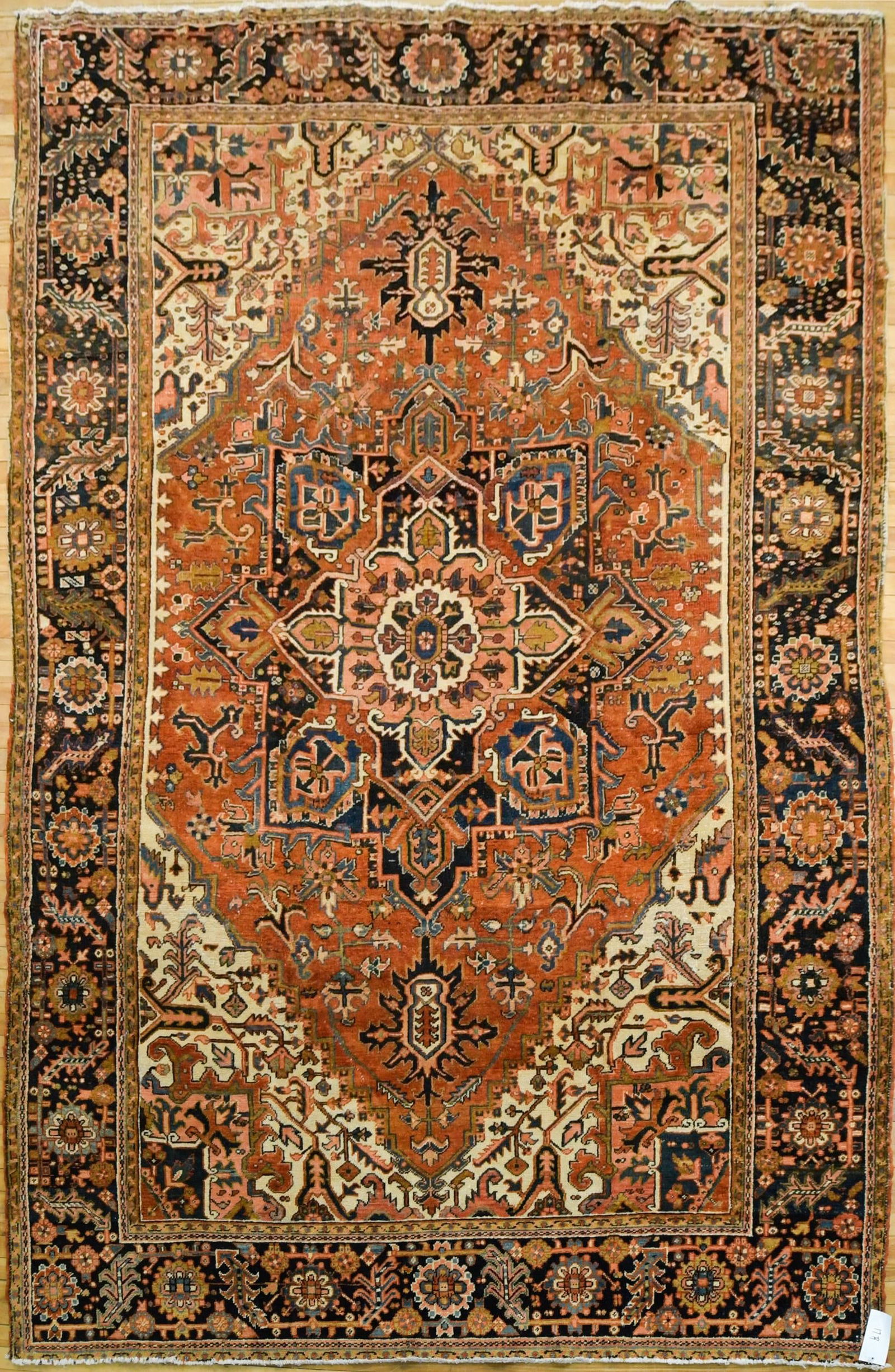 ANTIQUE ORIENTAL HERIZ ROOM SIZE RUG.: An antique Oriental Heriz room size rug, with classic multi point central medallion on brick red ground, highlighted with ivory, cobalt, and light blue. 8’3” x 11’5”.