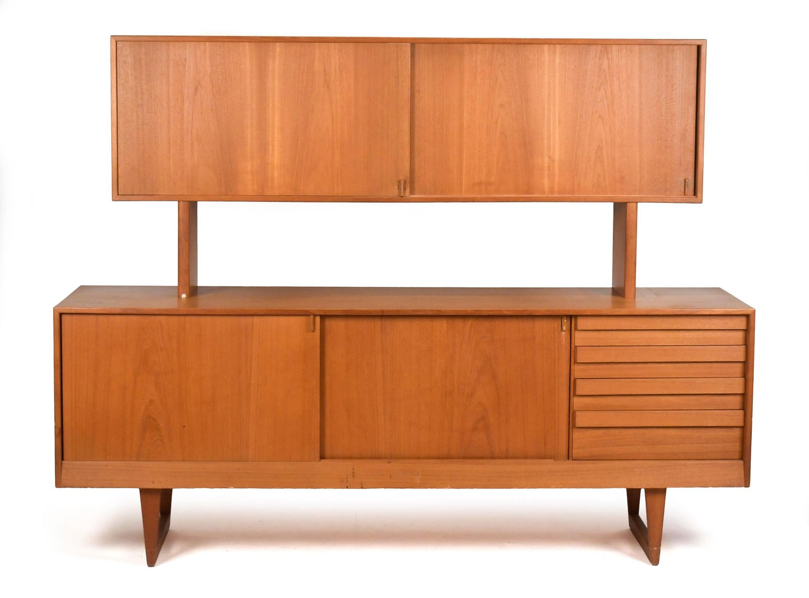 VINTAGE 20TH C. TEAK TWO-PART CREDENZA/HUTCH.: A vintage 20th C. teak two-part credenza/sideboard serving unit. A removable upper section with sliding doors that open to shelving, over a base section with sliding doors and drawers. No makers