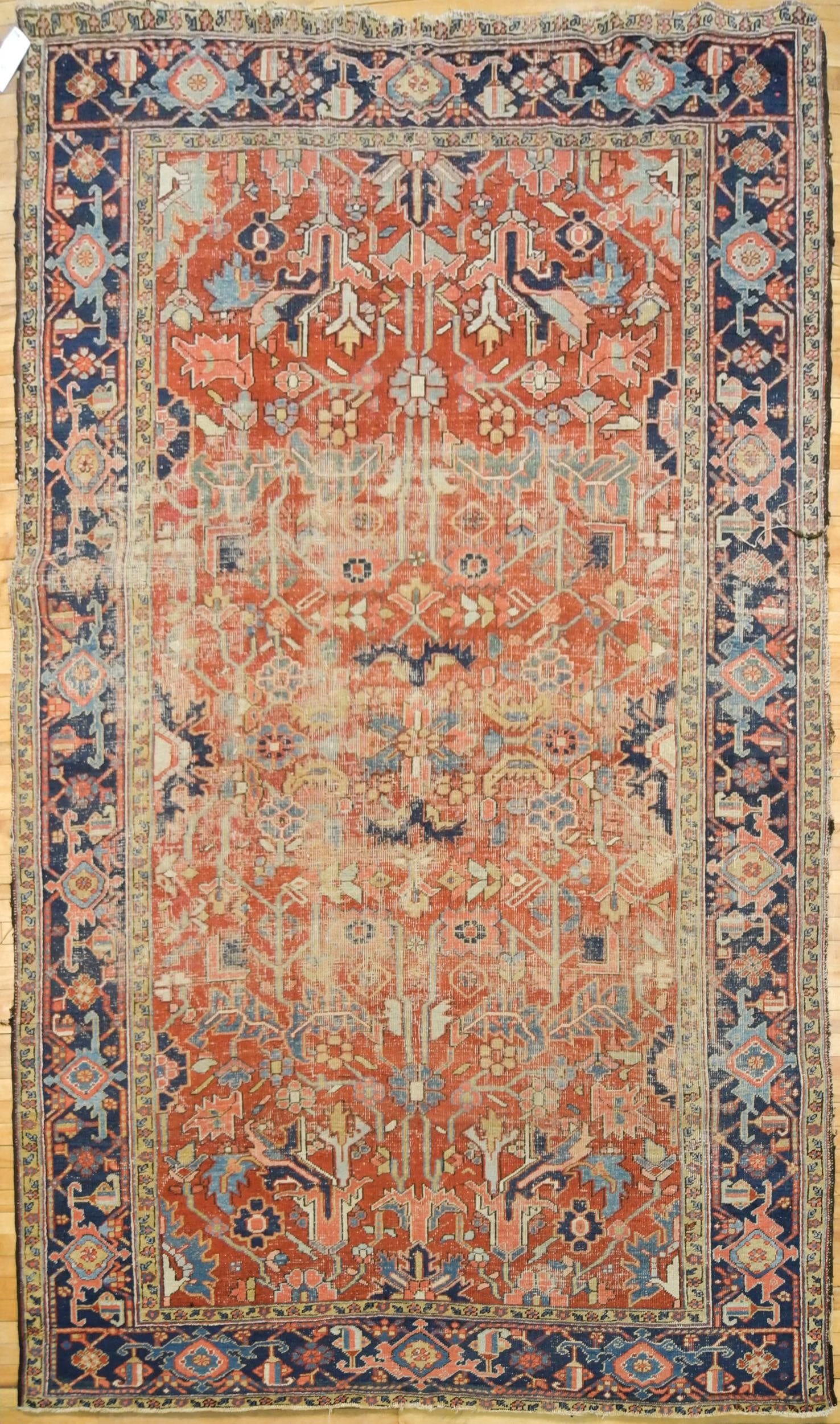 ANTIQUE ORIENTAL HERIZ ROOM SIZE RUG.: An antique Heriz room size rug, with geometric patterns on red ground, with dark blue border. 7’9” x 11’4.