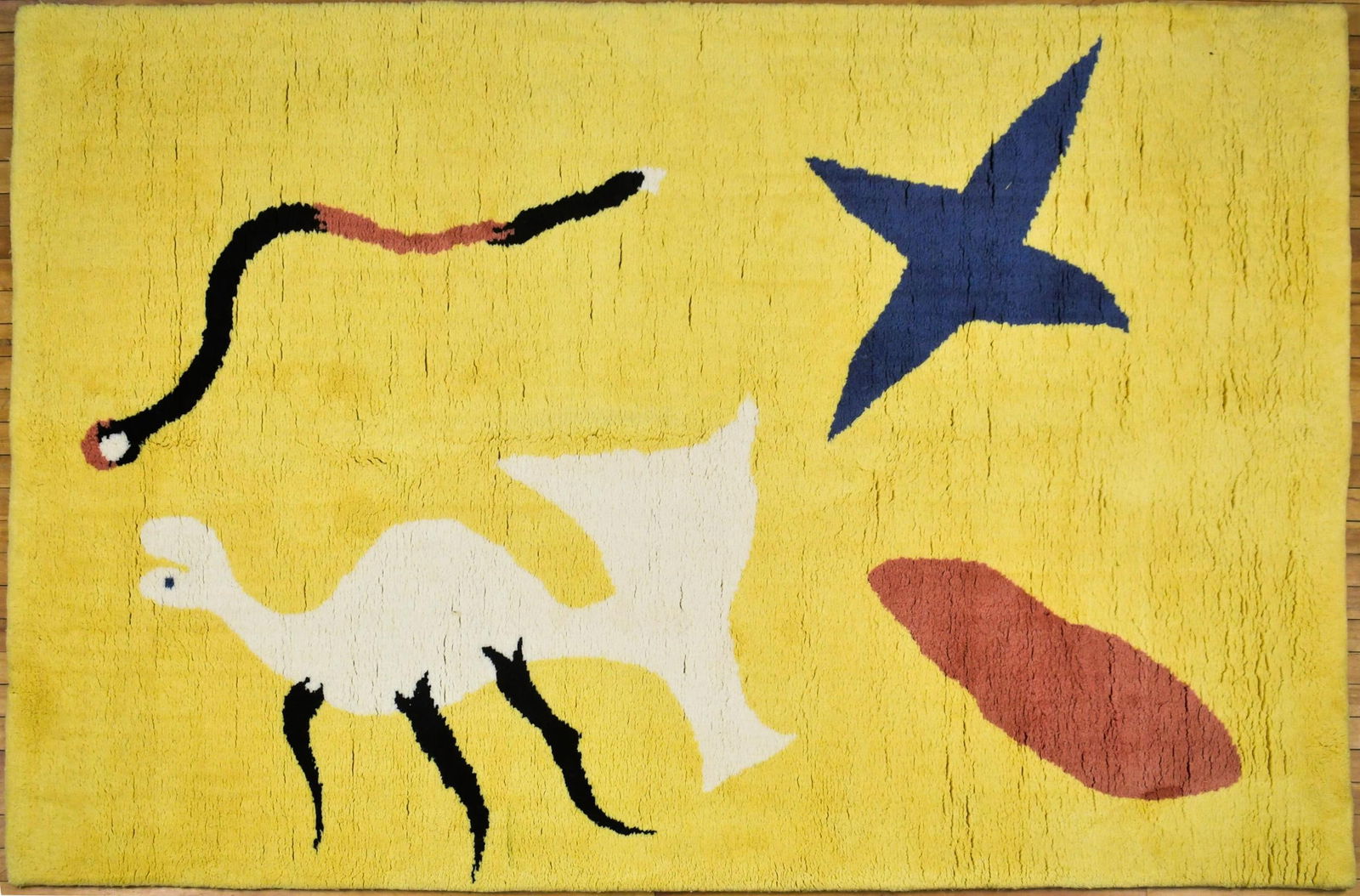 VINTAGE JOAN MIRO SIGNED AREA RUG.: A vintage wool area rug, after Joan Miro, titled ‘La Mangoust’, signed on reverse J. Miro. 5’ x 6’6”.