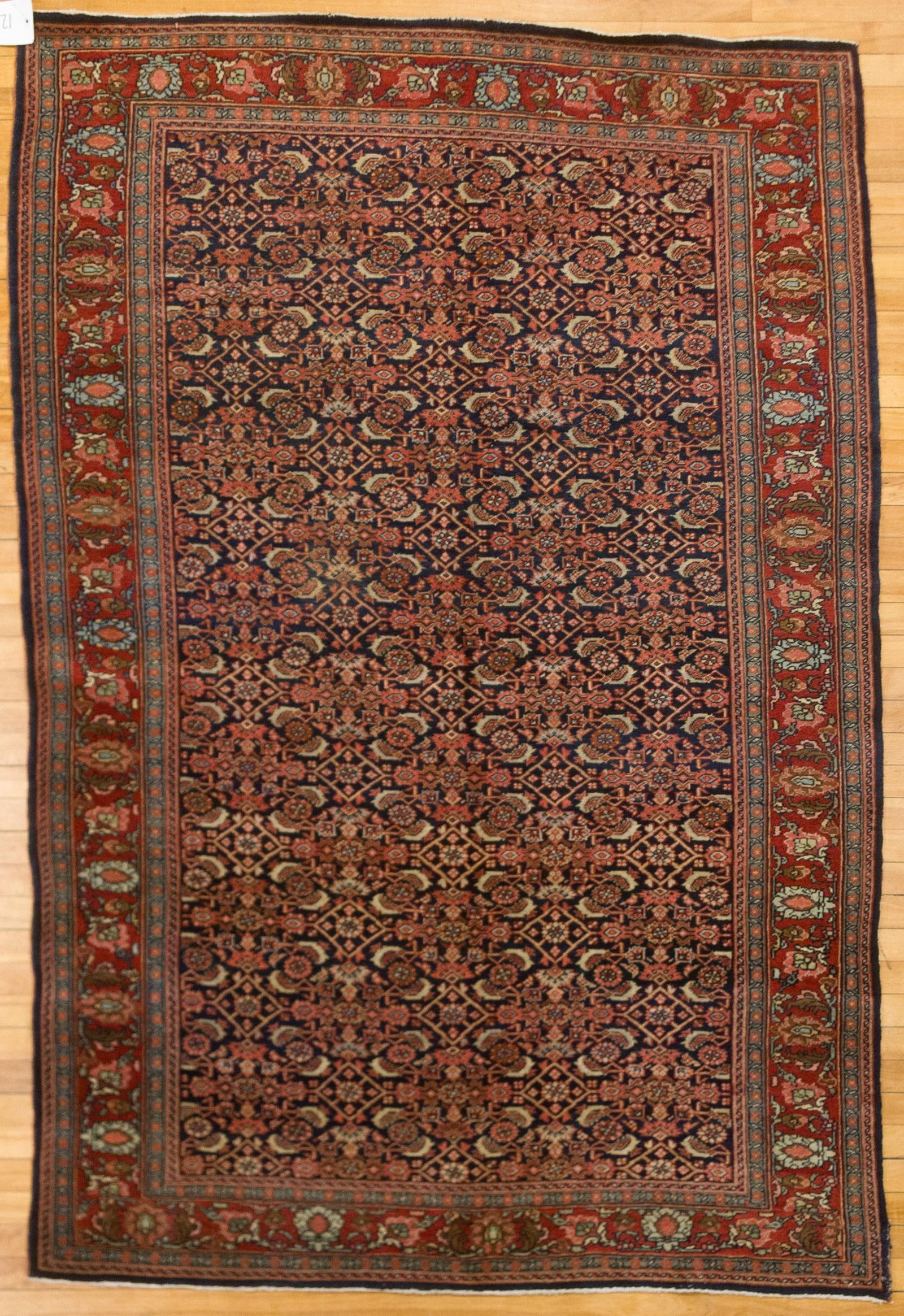 ANTIQUE BOKARA SCATTER RUG.: An antique Oriental Bokara scatter rug, with fish design on dark blue ground, red border. 4’8” x 7’5”.