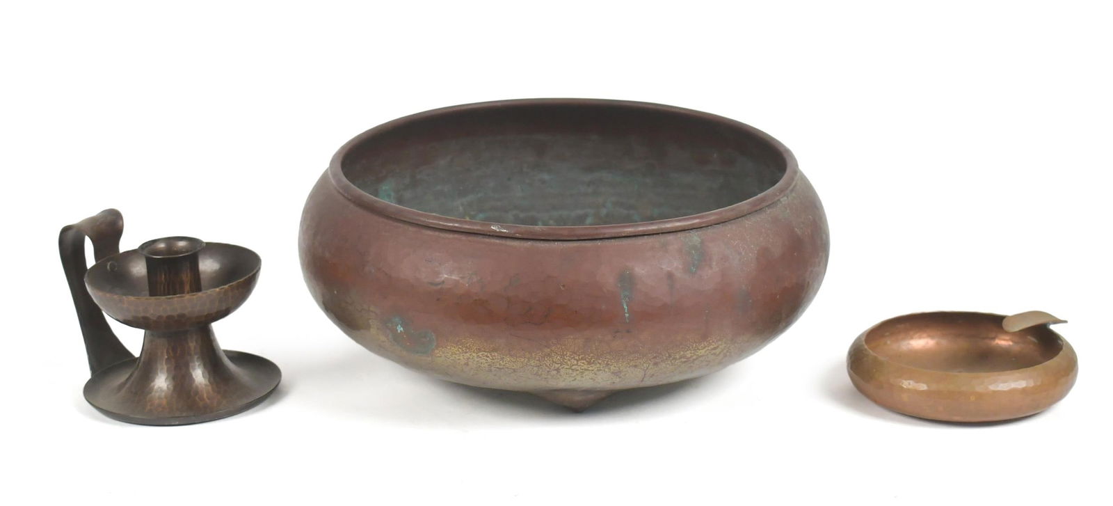 ROYCROFT COPPER JARDINIERE, ASHTRAY AND CANDLESTICK.: A Roycroft signed tri-foot hammered copper jardiniere 4”H x 10” dia, a Roycroft sign copper ash tray 4.5” dia., and a signed Roycroft chamber stick 3.5”H.