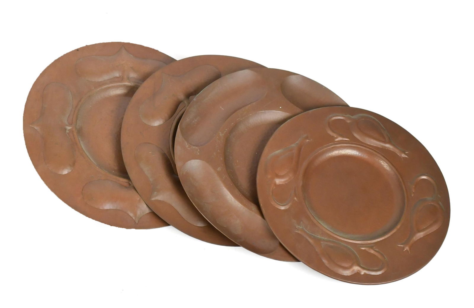 FOUR E.L.G. VINTAGE HAMMERED COPPER CHARGERS.: Four hand hammered copper chargers, each with pillowed embossed motifs, and marked on back E.L.G. with vessel insignia. All approx. 13” dia.