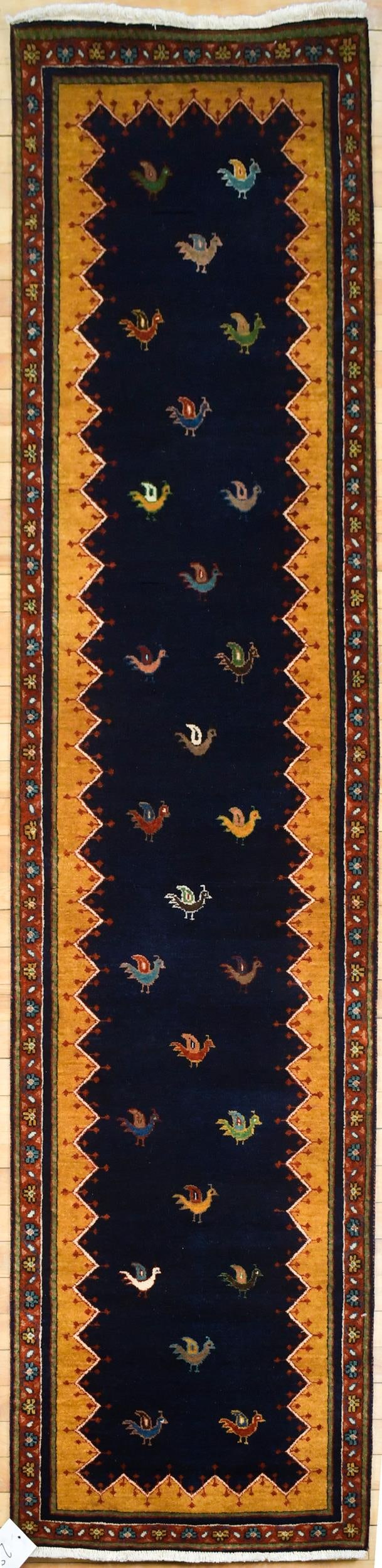 VINTAGE ORIENTAL GABBEH RUNNER.: A vintage hand woven Oriental Gabbeh runner with bird motif on dark blue ground. 2’1” x 8’.