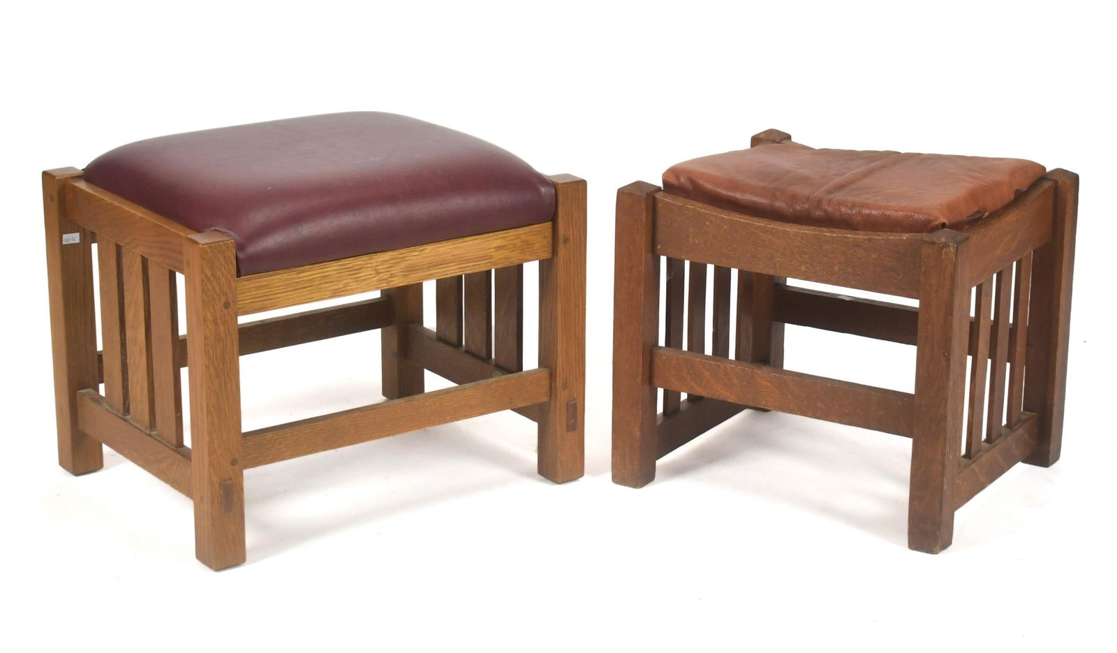 TWO ARTS & CRAFTS OTTOMANS.: A vintage unmarked Mission oak ottoman with maroon leather upholstery, 15.5”H x 18.5”W x 15”D. An antique Mission oak ottoman with no makers marks, 14”H x 16”W x