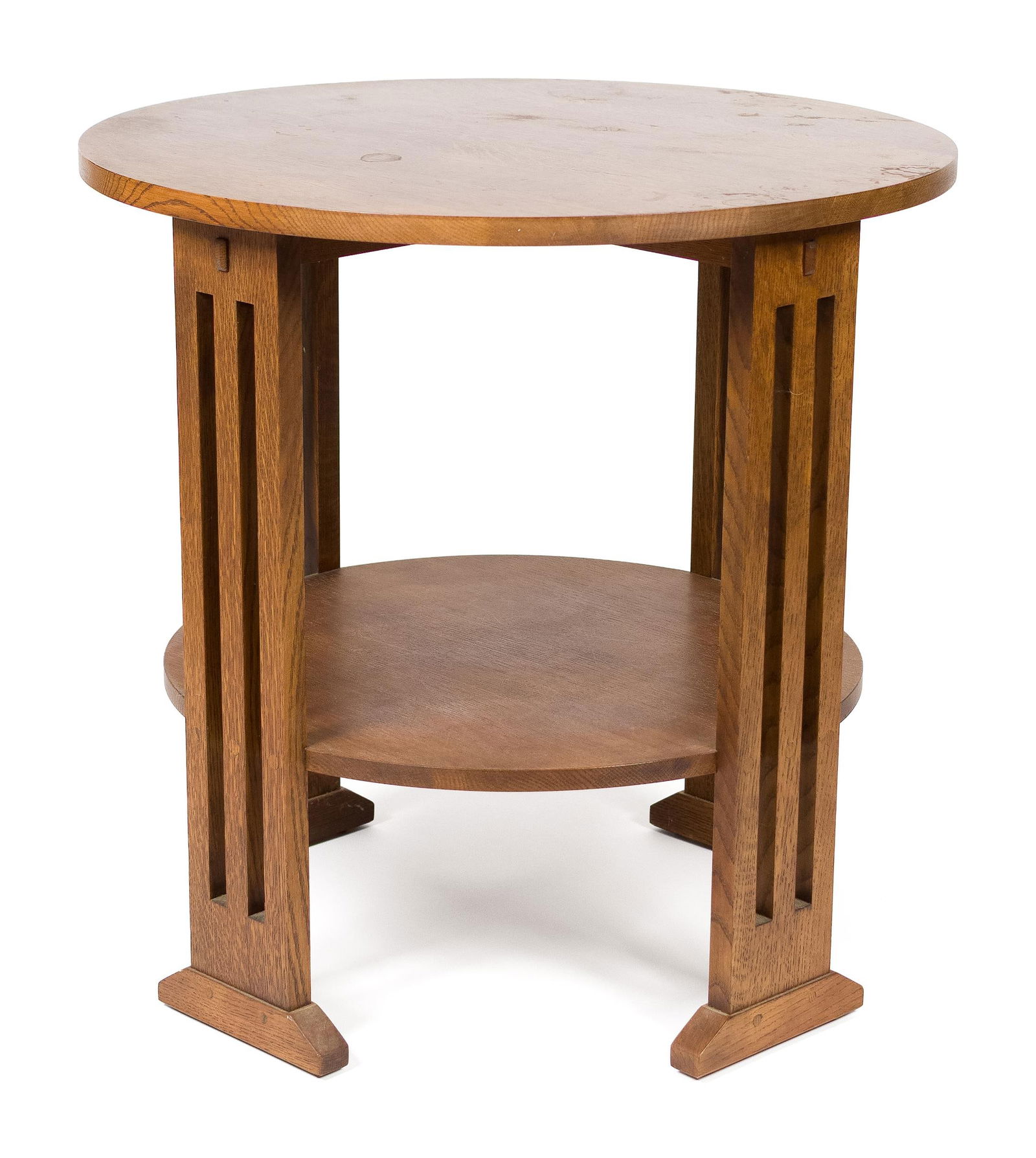 20TH C. ARTS & CRAFTS CIRCULAR OAK LAMP TABLE.: A 20th C. Stickley (Manlius NY) labeled Mission oak lamp table with a lower gallery/shelf and shoe feet.28.5”H x 29” dia.