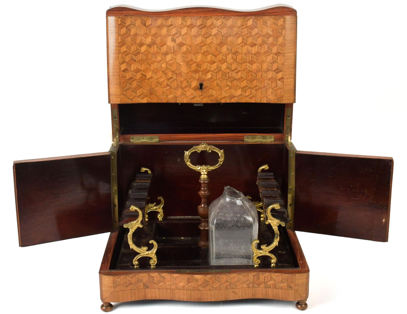 19TH C. PARQUETRY INLAID TANTALUS.: A late 19th C. parquetry inlaid serpentine form tantalus cabinet with fitted interior (no bottles), 10”H x 12.5”W x 10”D.