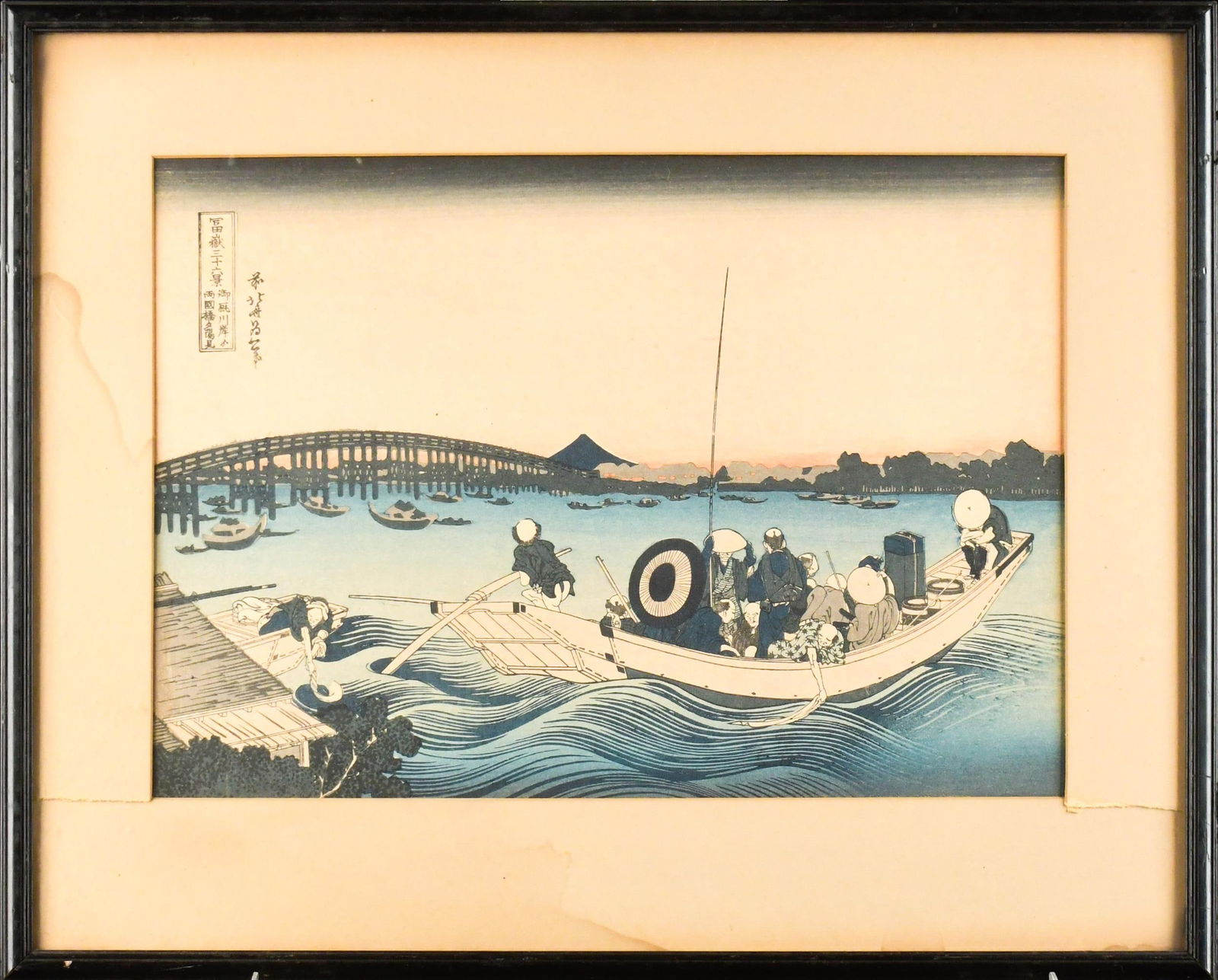 HOKUSAI WOODBLOCK, SUNSET OVER RYOGOKU BRIDGE.: A vintage Hokusai woodblock print, Sunset over Ryogoku Bridge’. Image 10” x 14”, Overall in frame 15” x 19”.