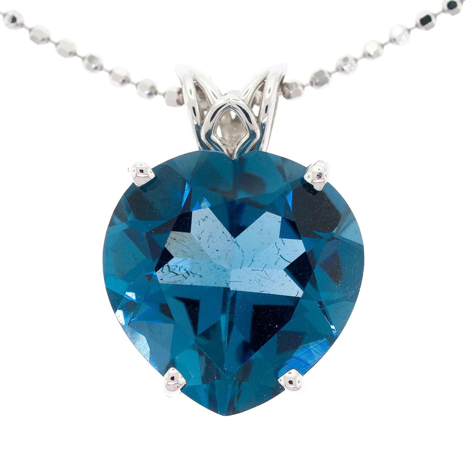 14K GOLD HEART SHAPED BLUE TOPAZ NECKLACE.: A 14k white gold (stamped) heart pendant set with an approx. 15 ct., faceted heart shaped, dark blue topaz, approx. 1 inch long and a 14k white gold (stamped) faceted ball chain, 1.37mm thick, 18 inch