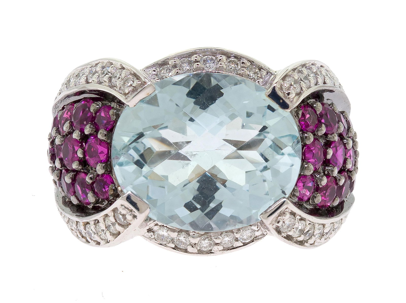 SONIA B. 18K GOLD AQUA, SYN. RUBY & DIAMOND RING.: A signed, Sonia B., 18k white gold (stamped) ring set with an approx. 6.5 ct., faceted top oval, light blue aquamarine, approx. .25 ct. tw., round brilliant cut, natural diamonds of G-H color and VS-S