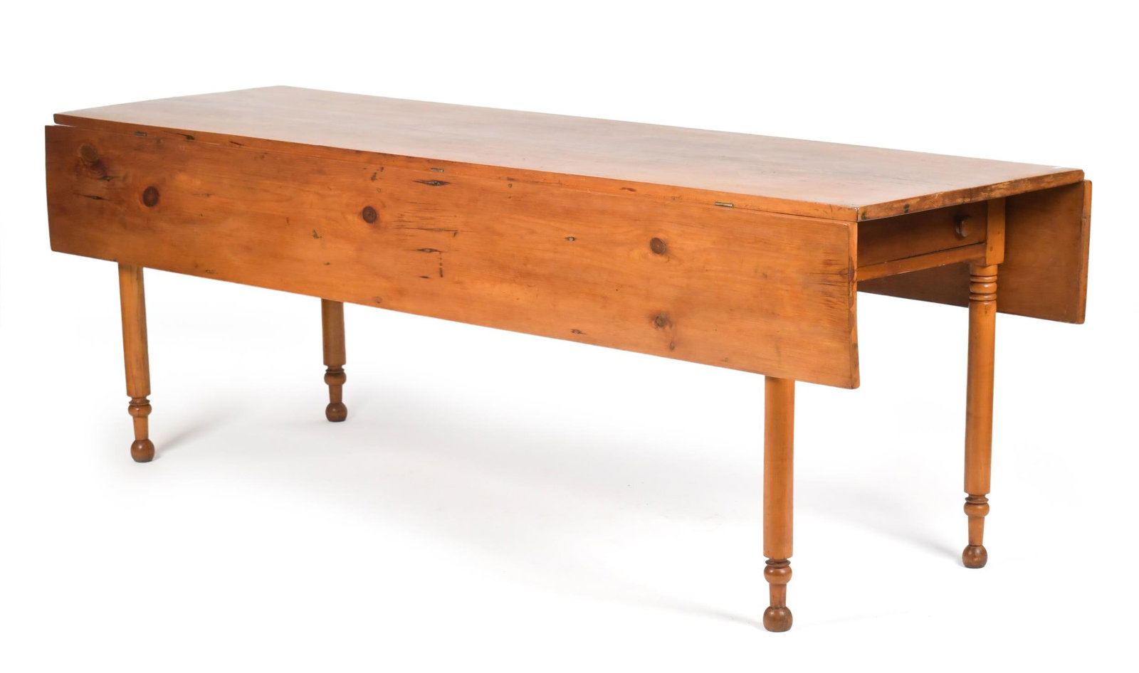 ANTIQUE SHERATON HARVEST TABLE.: A 19th C. Sheraton drop leaf pine harvest table with a single drawer in one end, on turned Sheraton legs. 29”H x. 85”L x (26”D leaves down x 44” leaves up).