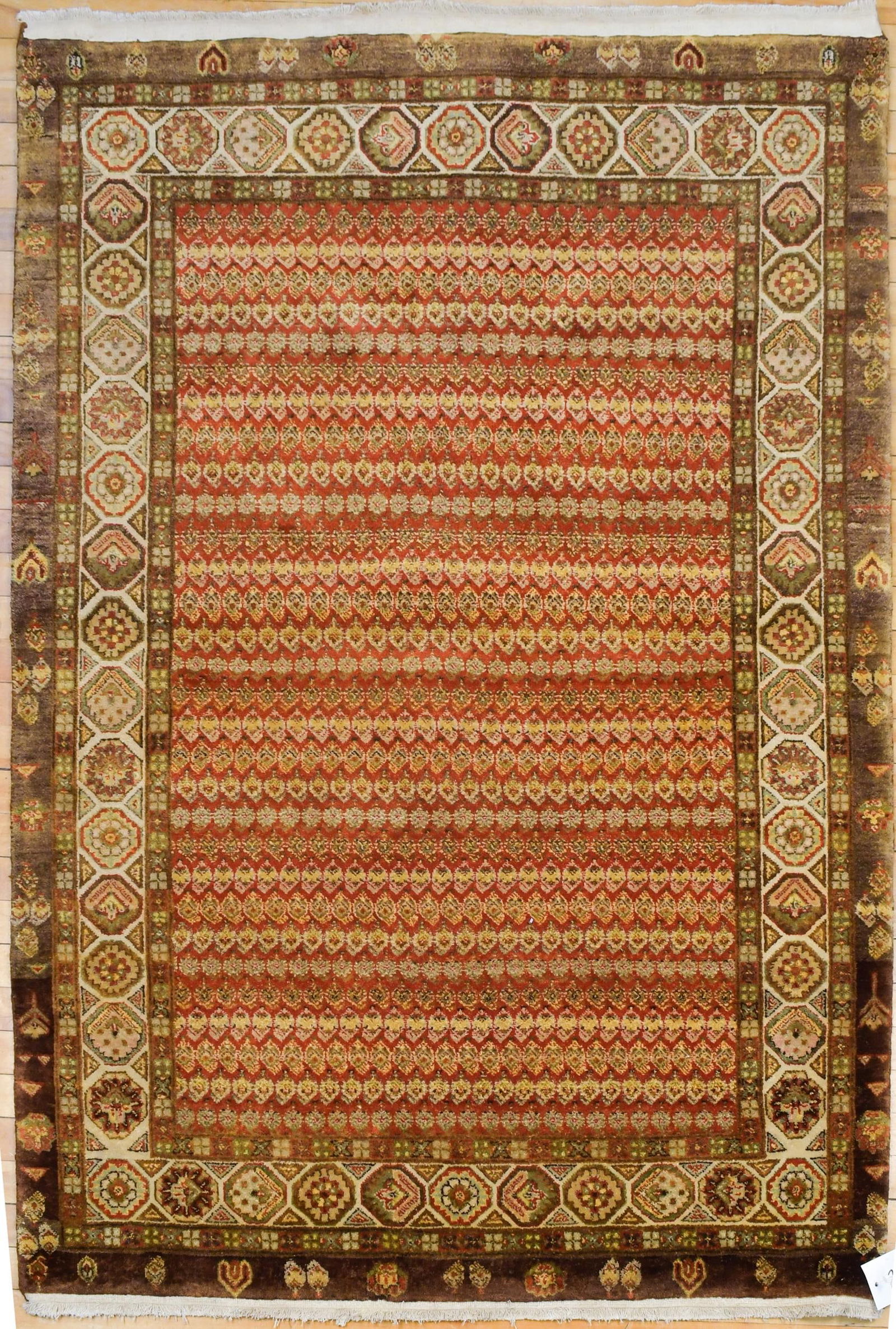 VINTAGE ORIENTAL SCATTER RUG.: A vintage Oriental Seraband scatter rug, with red ground and repeating boteh designs in earth tones.4’1” x 5’8”
