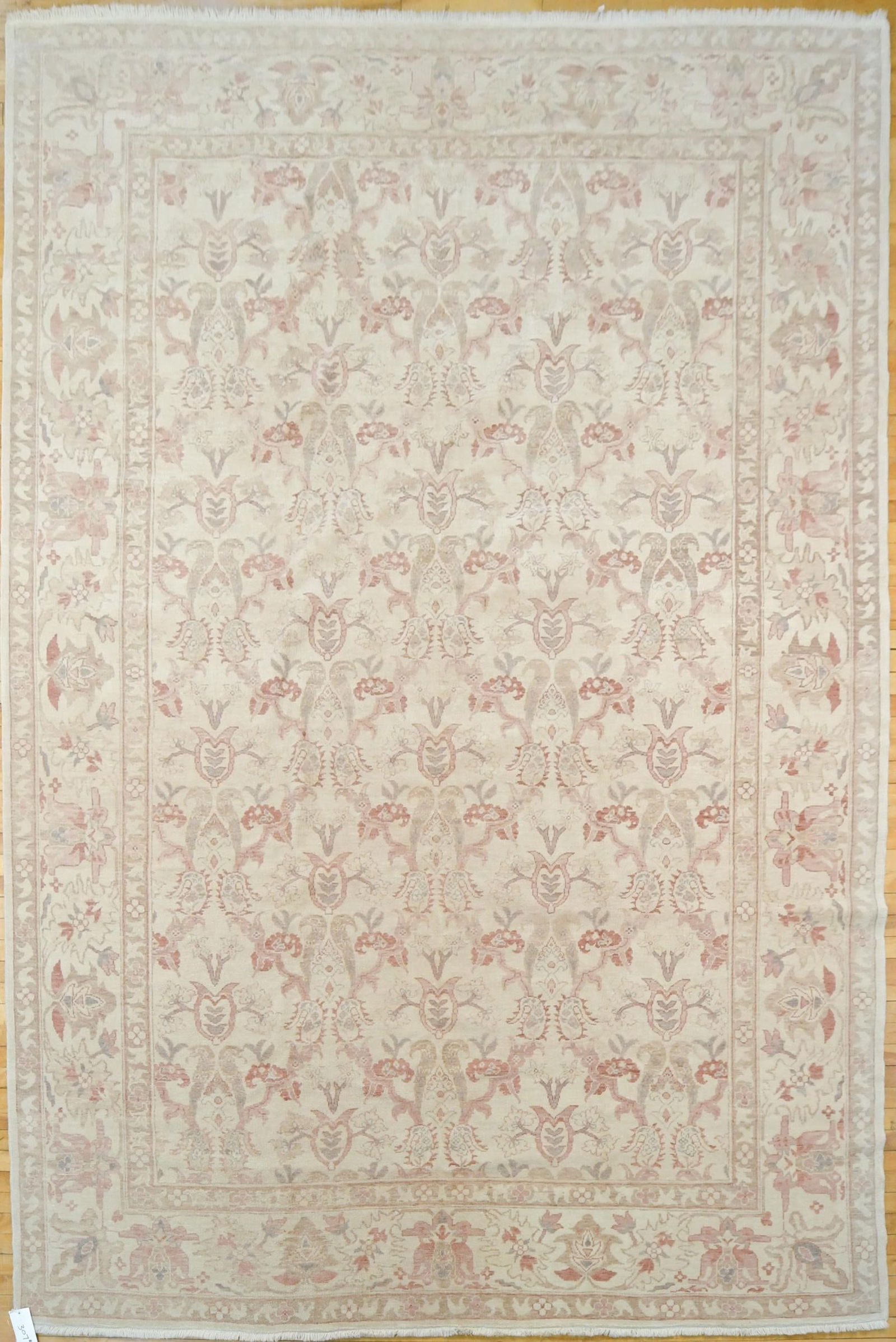 VINTAGE ORIENTAL OUSHAK ROOM SIZE RUG.: A vintage hand woven room size Oushak rug, with raspberry and tan floral designs on ivory field. 9’3” x 11’7”.