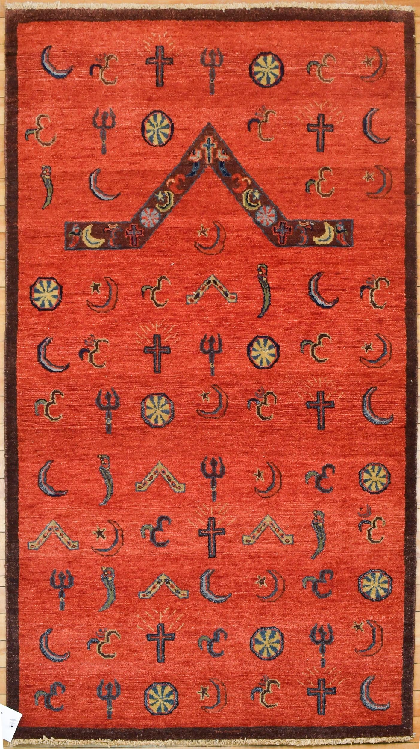 VINTAGE ORIENTAL SCATTER RUG.: A vintage hand woven Oreintal scatter rug, with ruby red ground, unique geometric design, crescent moon, crosses and more. 3’1” x 5’2”