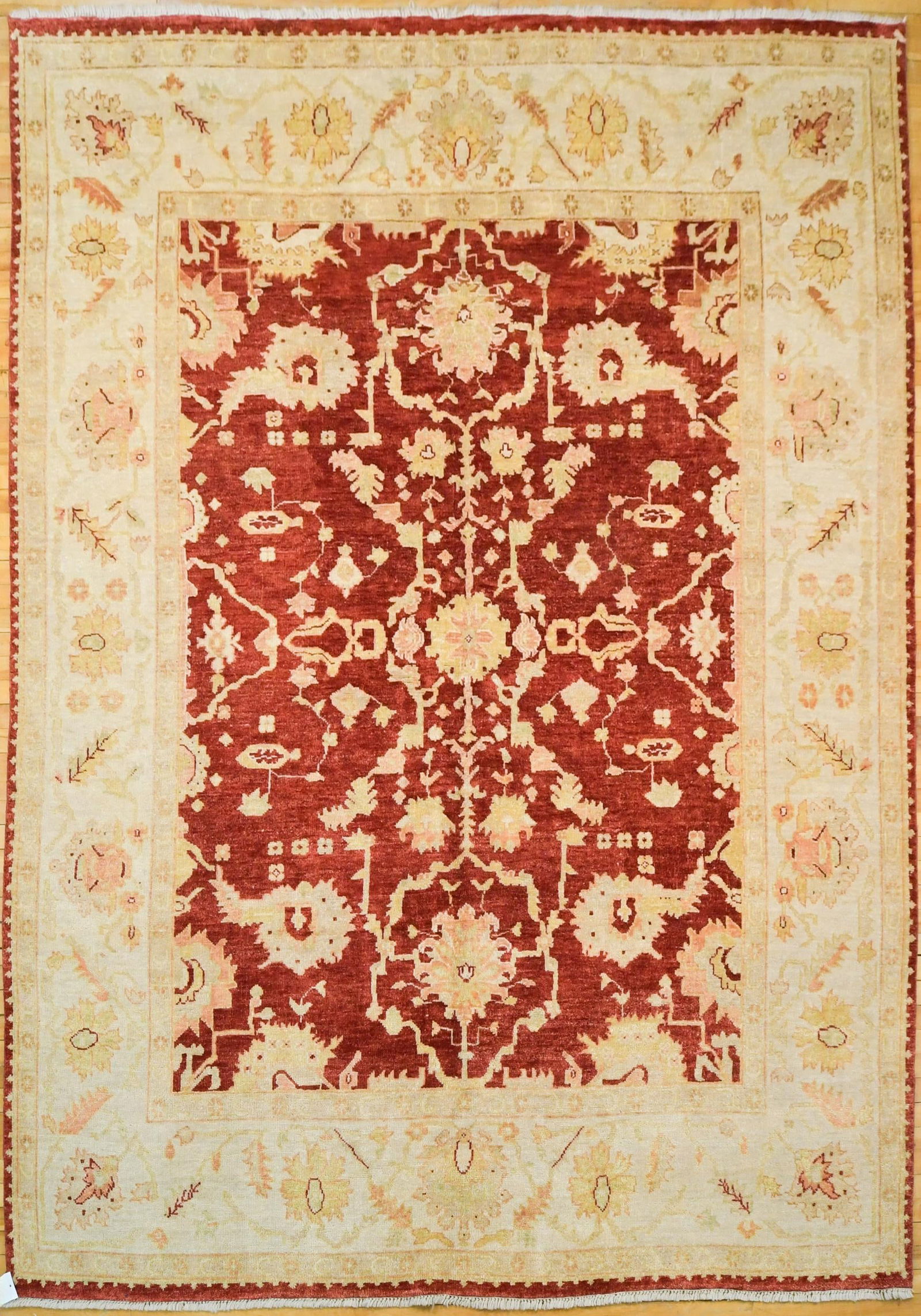 VINTAGE ORIENTAL OUSHAK ROOM SIZE RUG.: A vintage hand woven Oriental Oushak rug, cranberry red ground, highlighted with ivory, salmon, yellow and green. 8’1” x 10’.