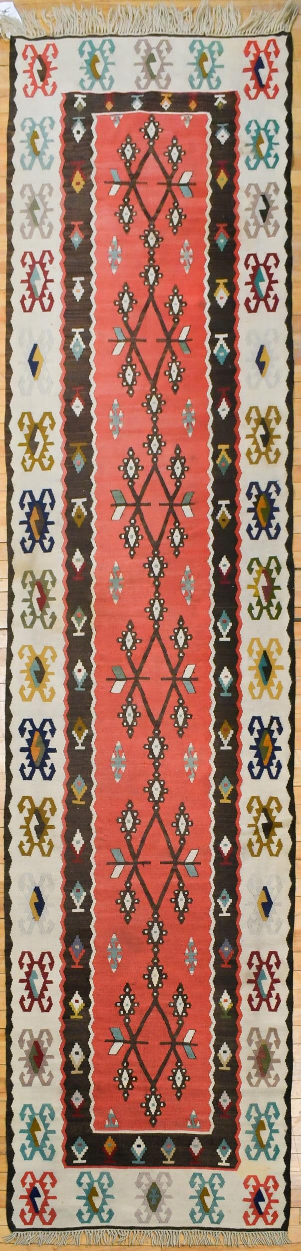 VINTAGE TURKISH KILIM RUNNER.: A vintage Turkish Kilim runner, in red and brown.3’5” x 13’