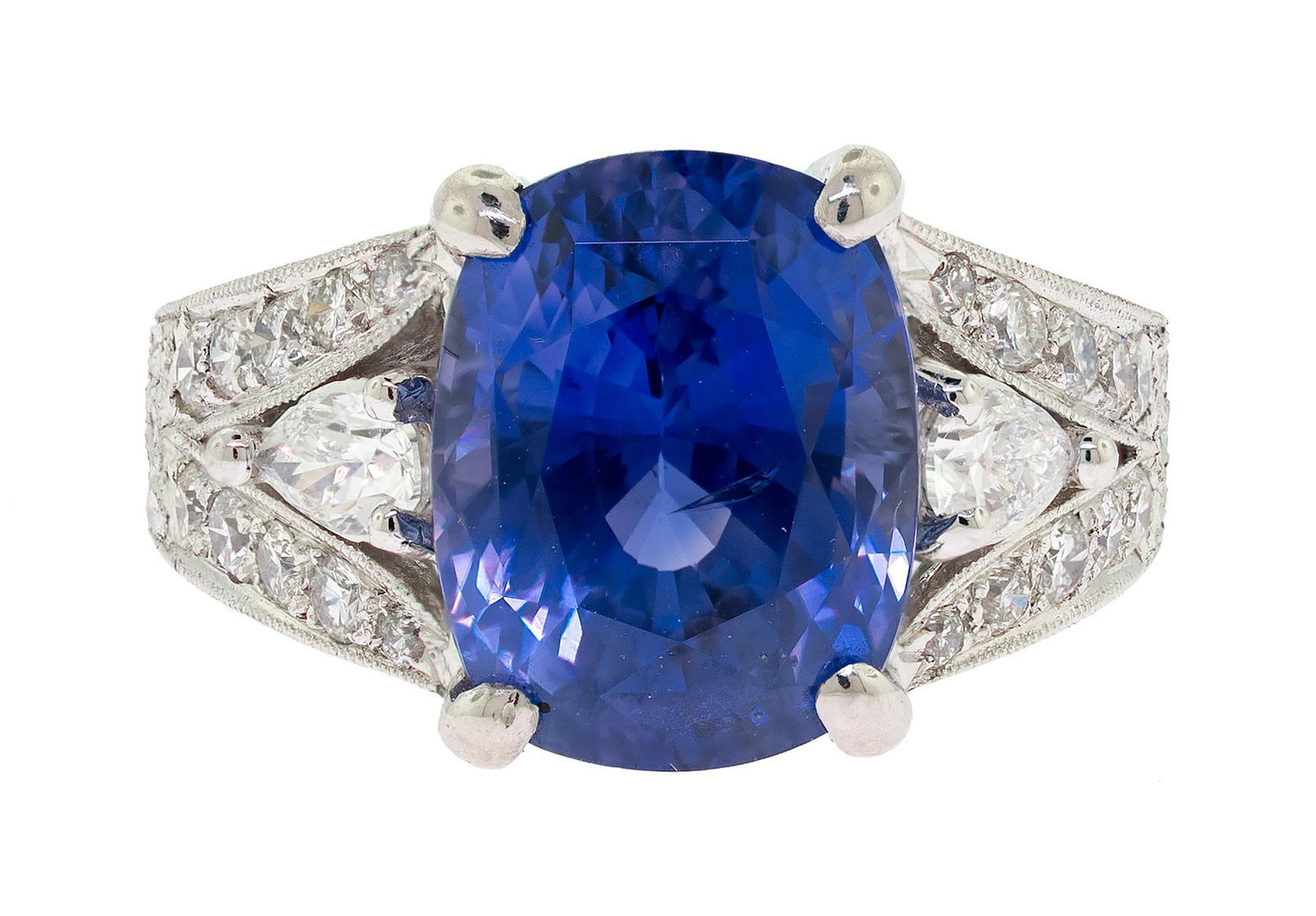 STUNNING PLATINUM 8.10 CT. SAPPHIRE & DIAMOND RING.: A stunning platinum (stamped), hand-engraved ring set with an 8.10 ct., cushion cut, medium, slightly violetish blue, sapphire and .98 ct. tw., round brilliant and pear shaped, natural diamonds of G-H